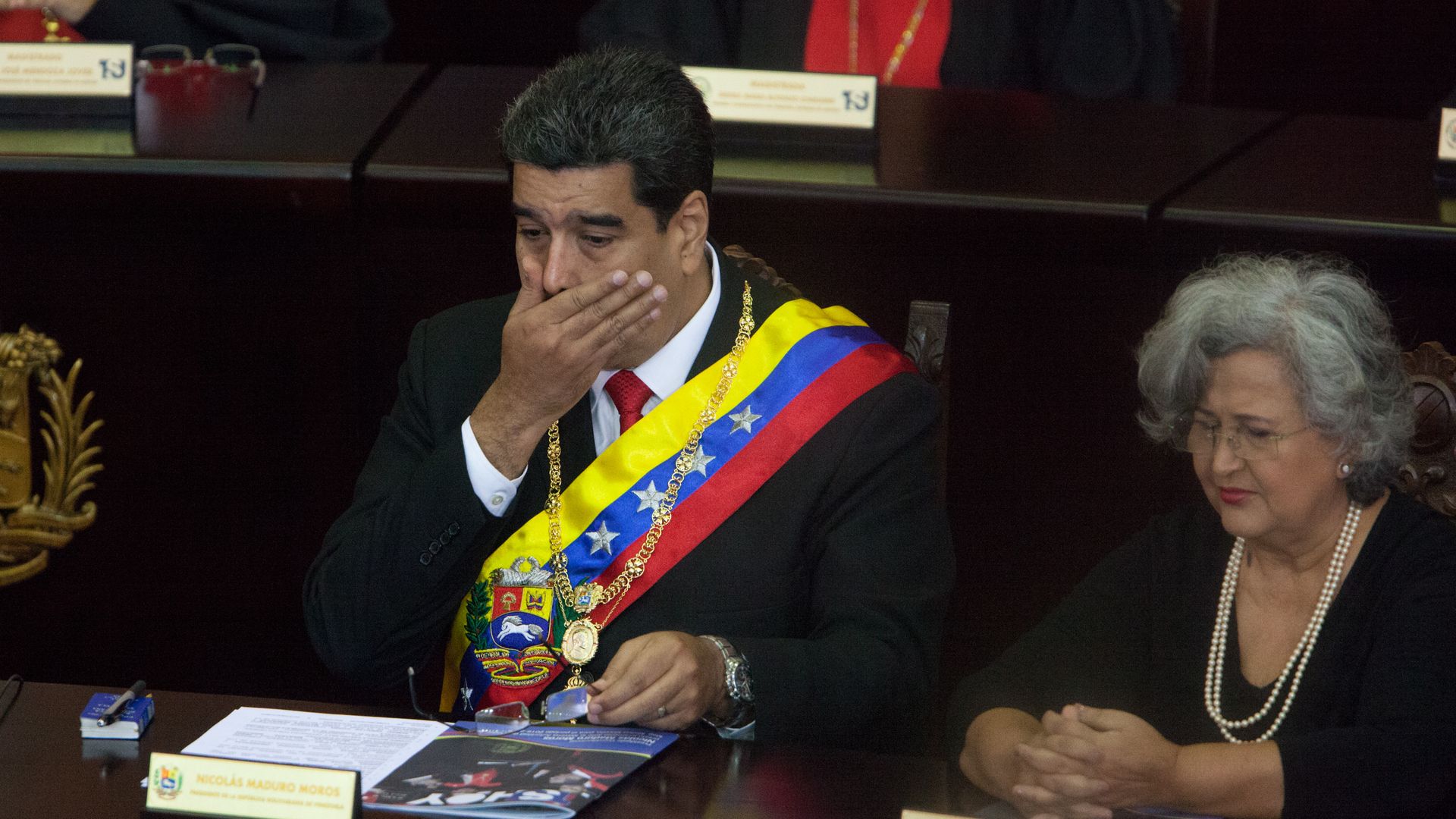 Nicolas Maduro covers his mouth and looks shocked.