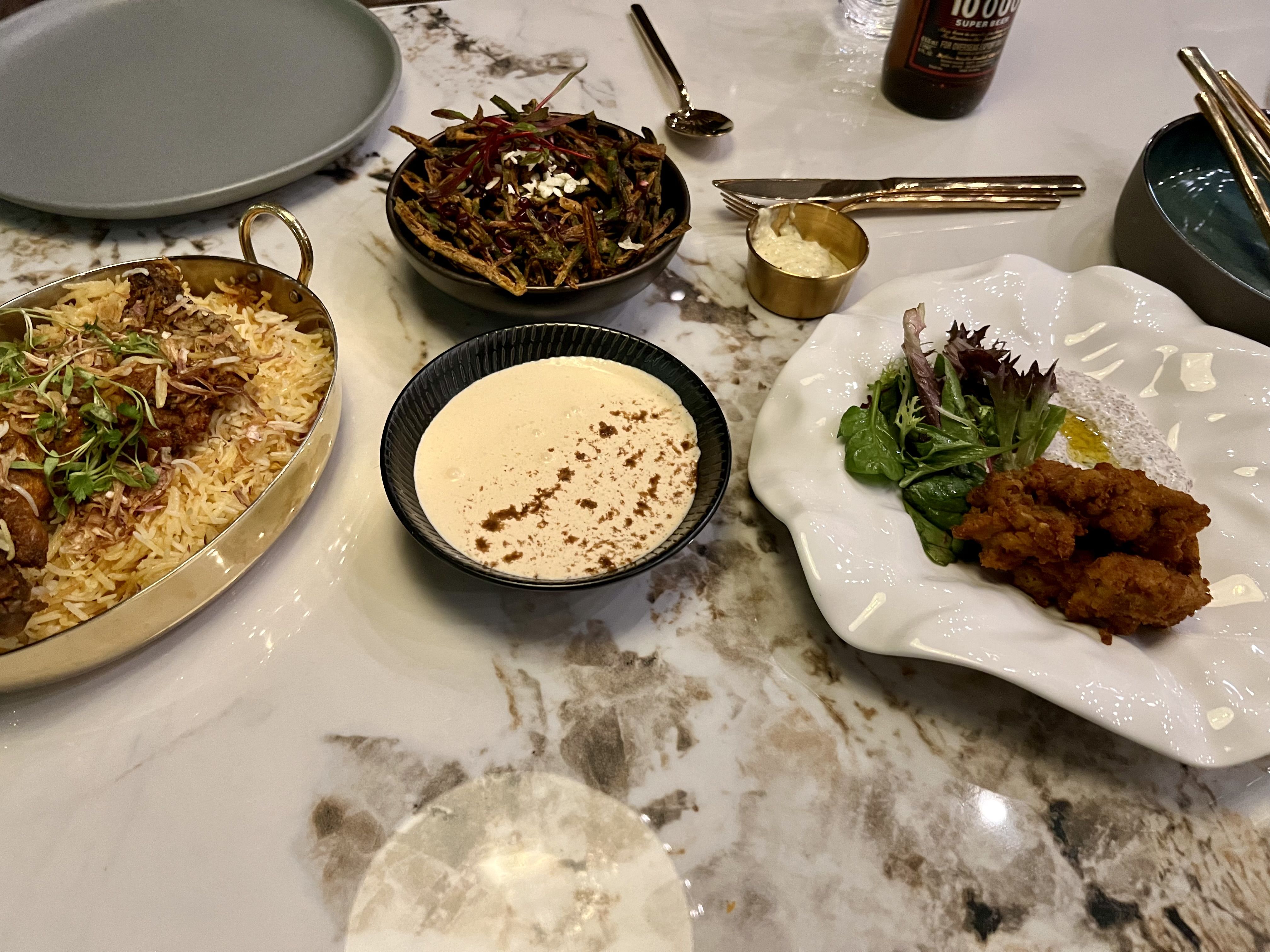 Several plates of Indian food sit on a table