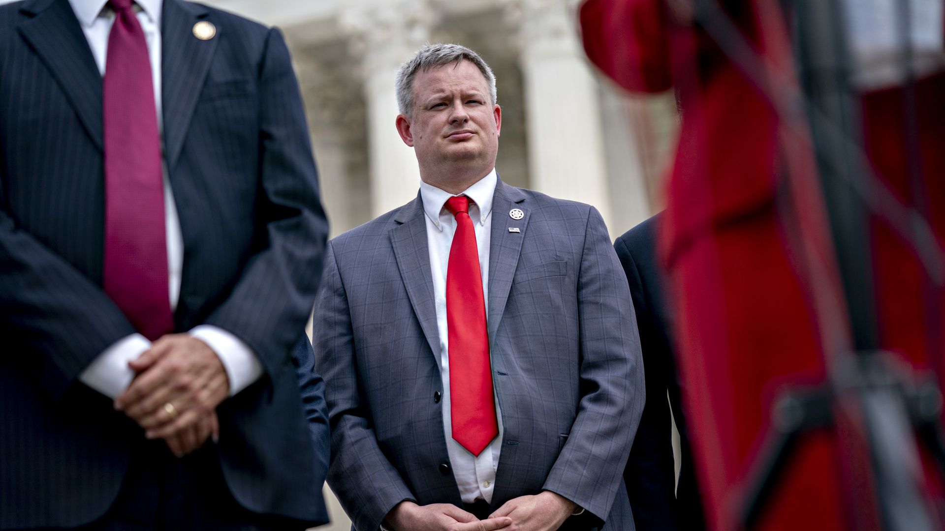 Photo of Jason Ravnsborg standing with his hands linked in front of him