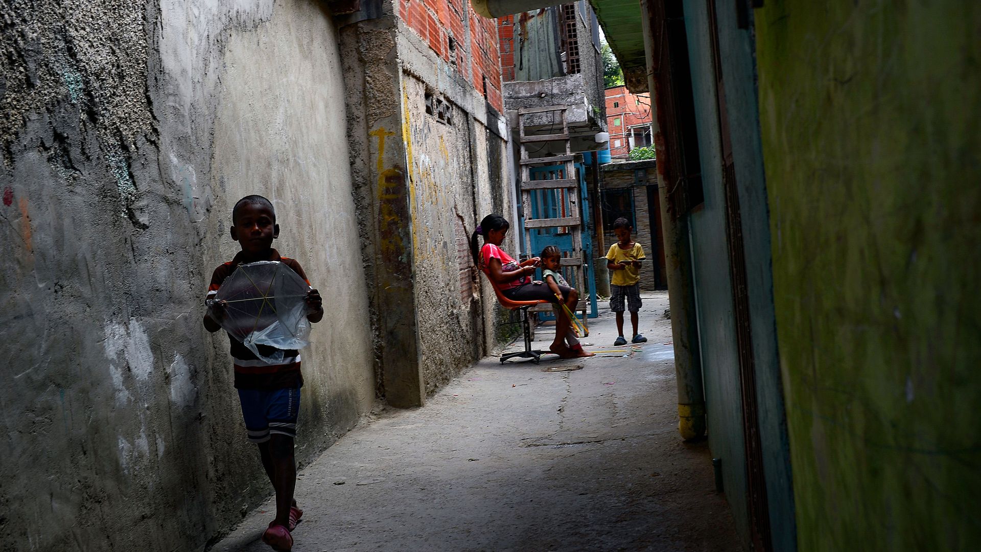 A woman braids her daughter's hair at Petare slum in Caracas, Venezuela, on September 29, 2019. (Photo by Matias Delacroix