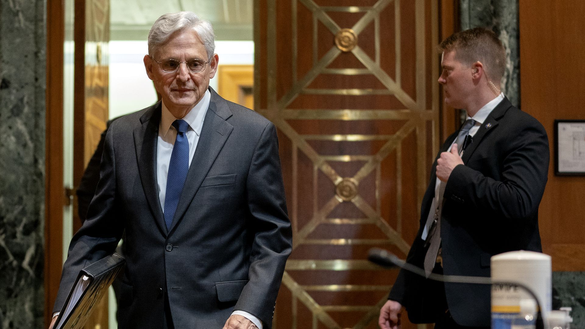 Picture of Merrick Garland holding a binder and walking