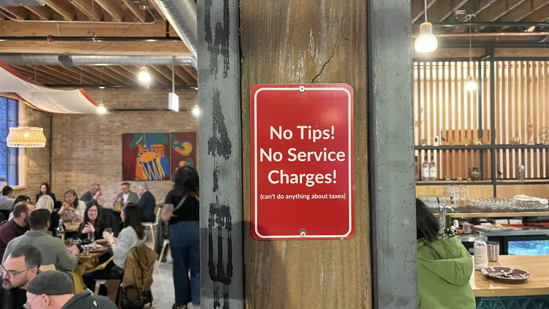 Red sign that reads No Tips! No Service Charges!