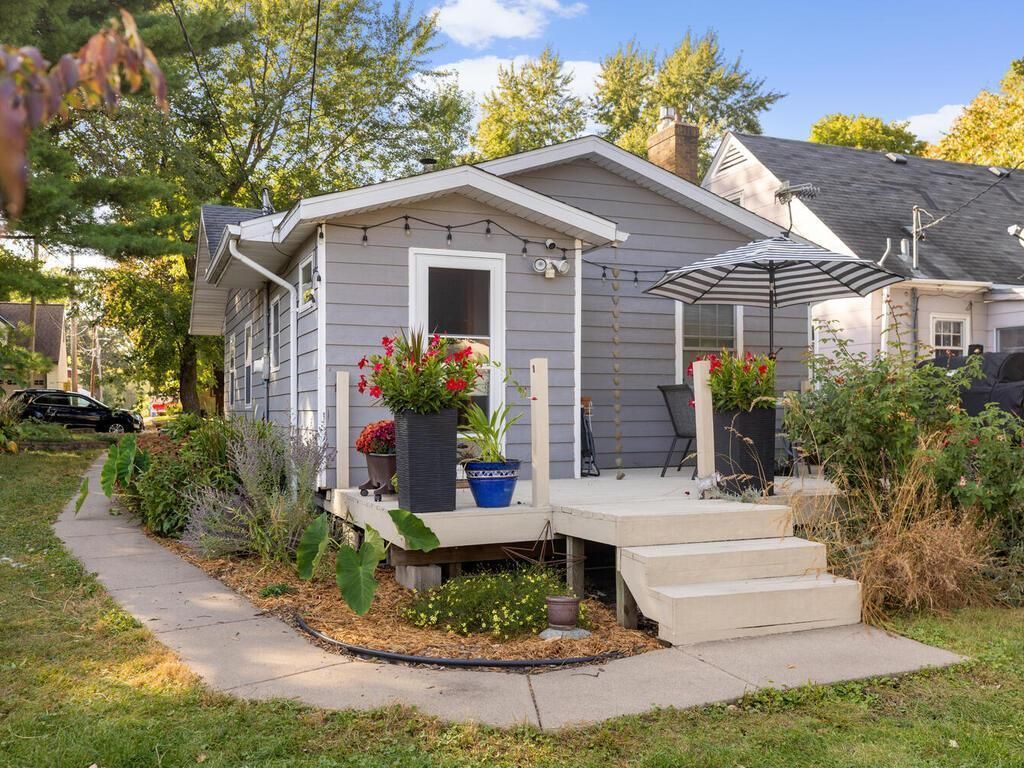 The back of a gray house with a back deck and patio chairs.