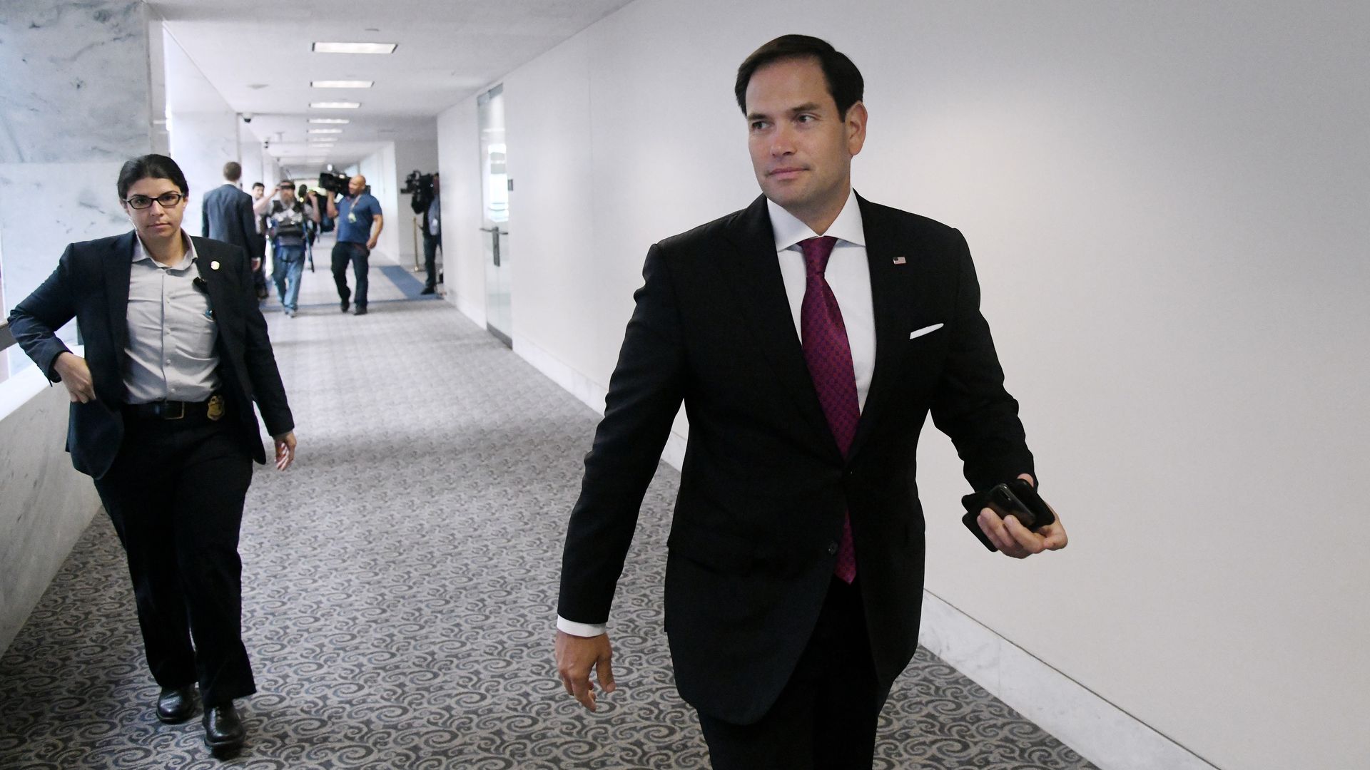 Marco Rubio walking in a hallway