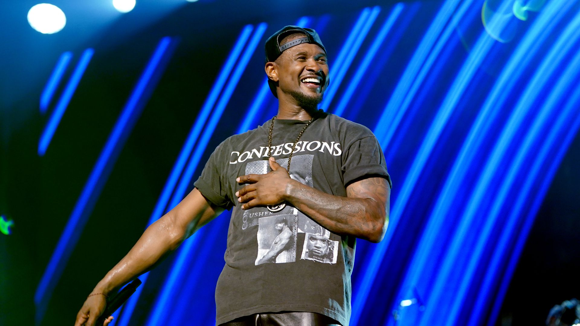 Photo shows Usher smiling on stage.