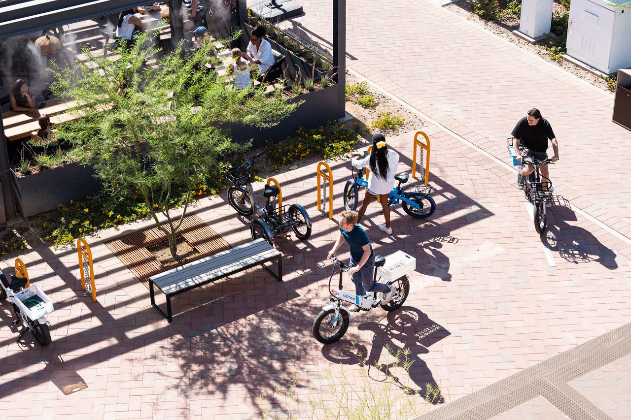 People riding e-bikes through a paseo.