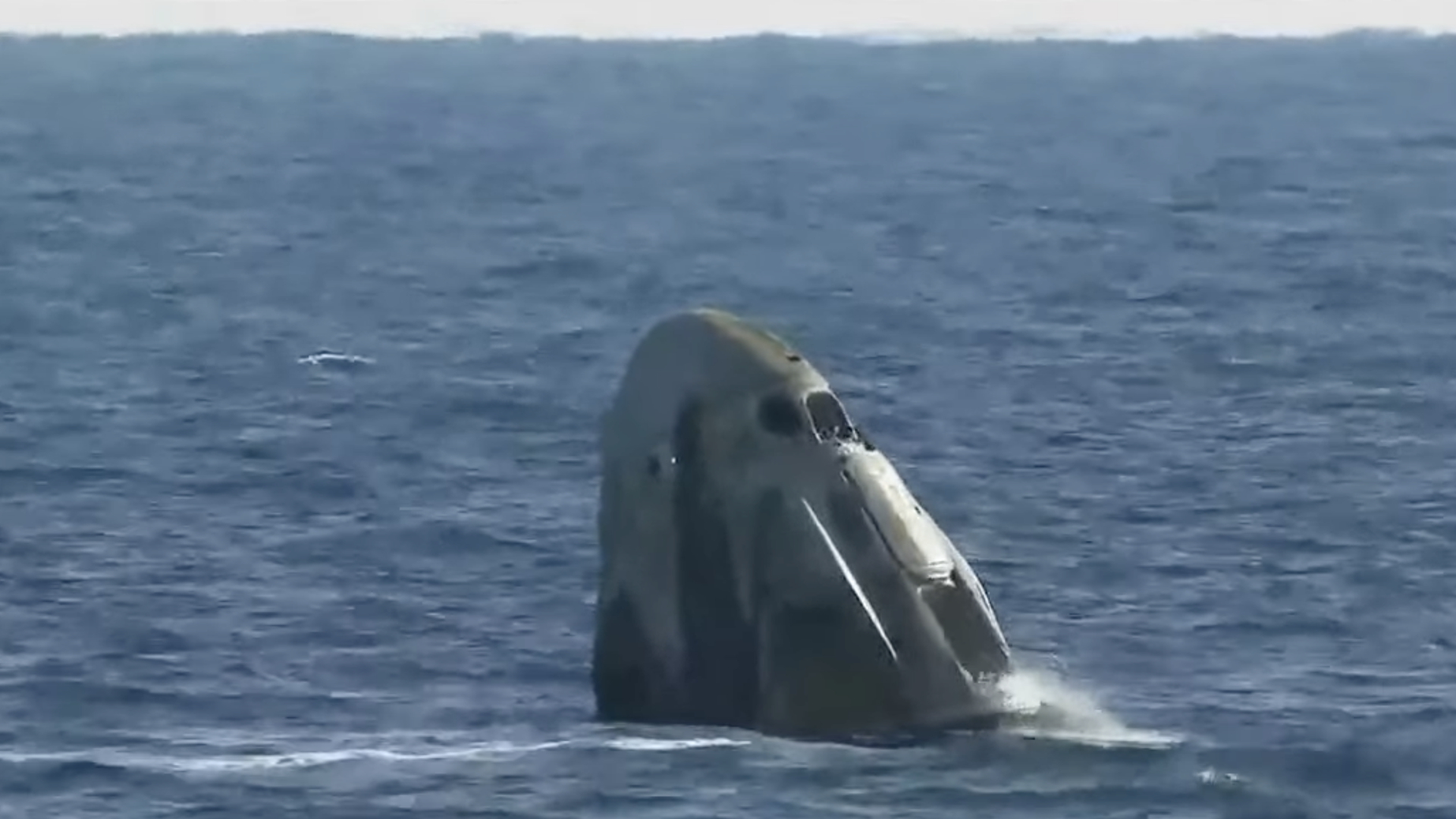 A SpaceX capsule carrying crewmembers bobs in the waters of the Atlantic Ocean.