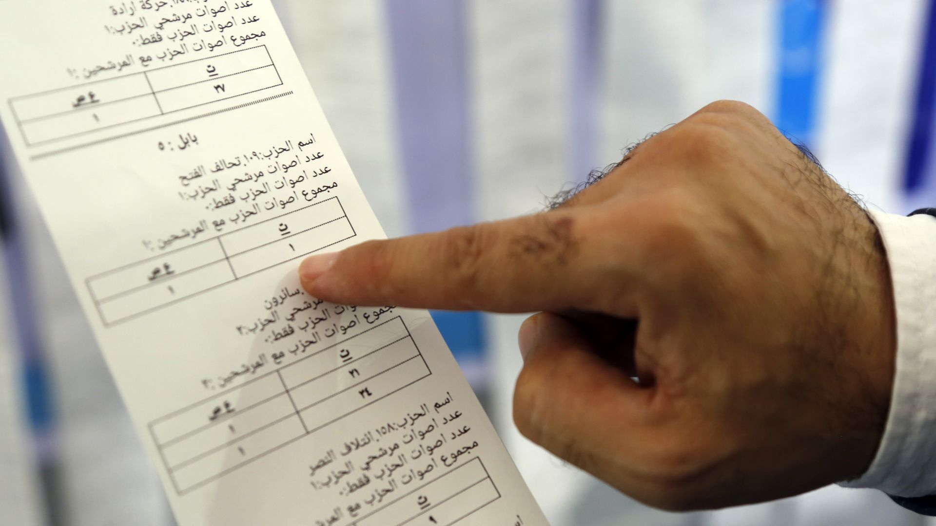 An Iraqi official examining a ballot