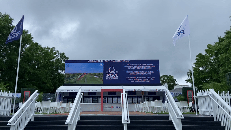 Flags wave in the air in front of a sign letting people know that spectators aren't allowed at Quail Hollow Club Monday due to weather. 