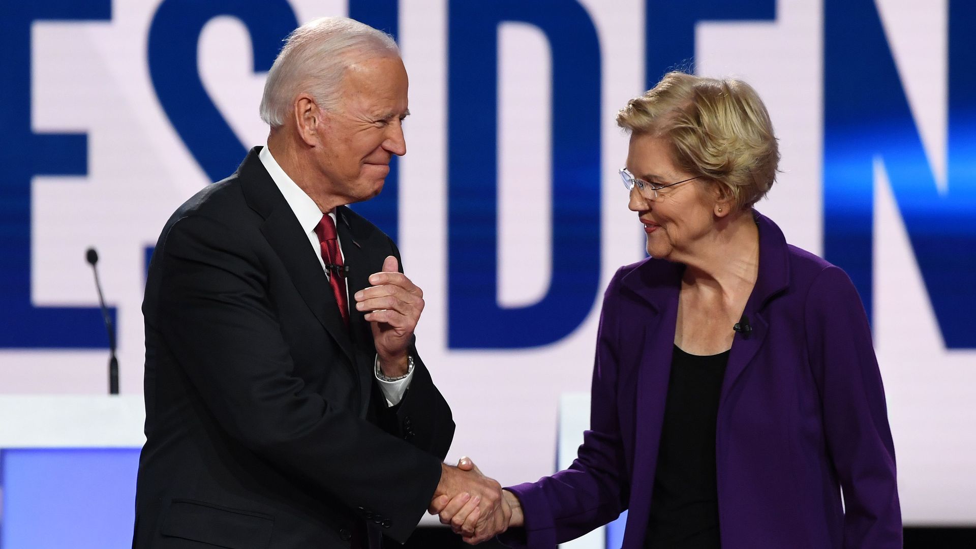 Elizabeth Warren and Joe Biden shake hands on the debate stage. 