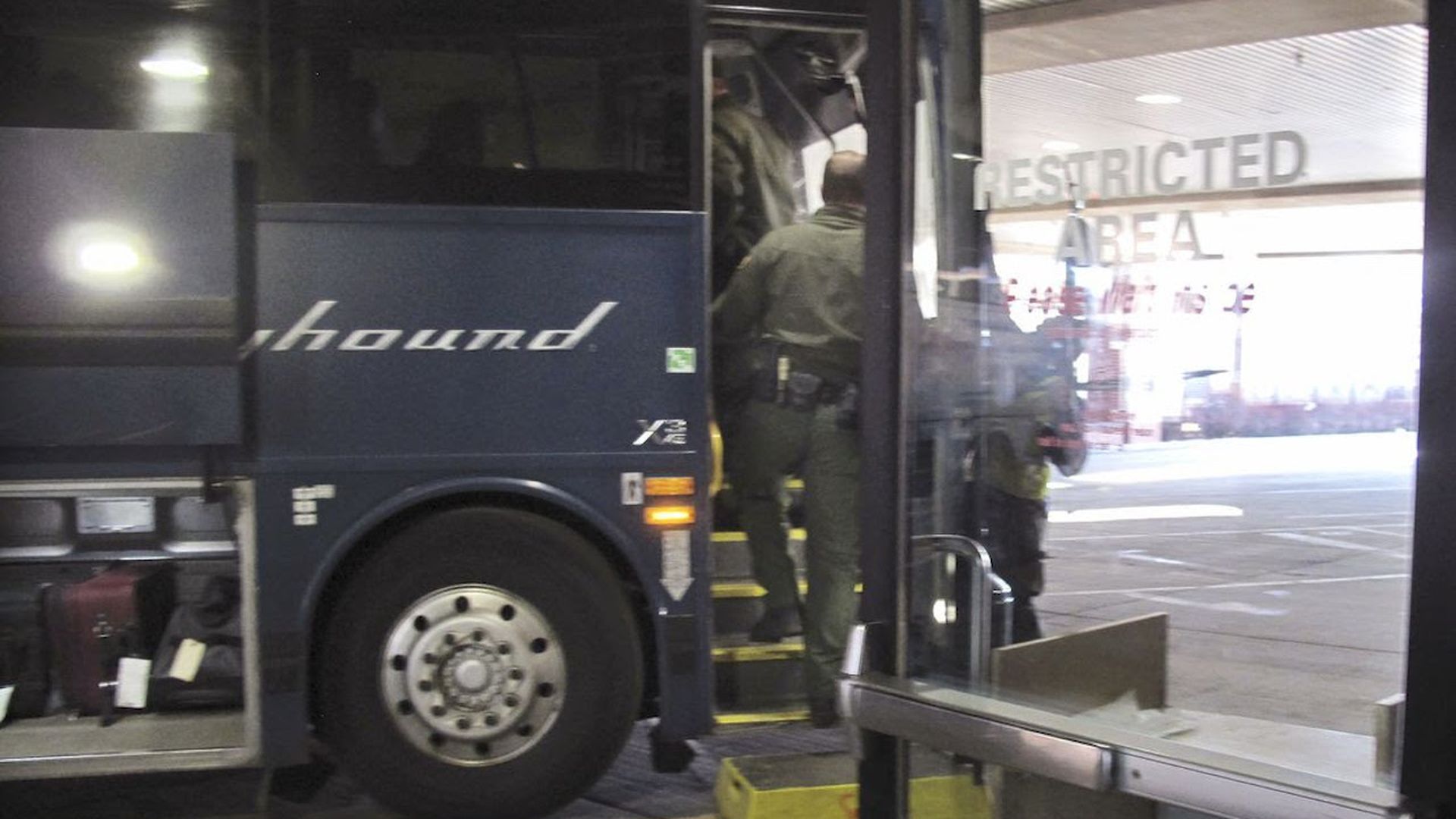 Customs and Border Protection agents board a Greyhound bus