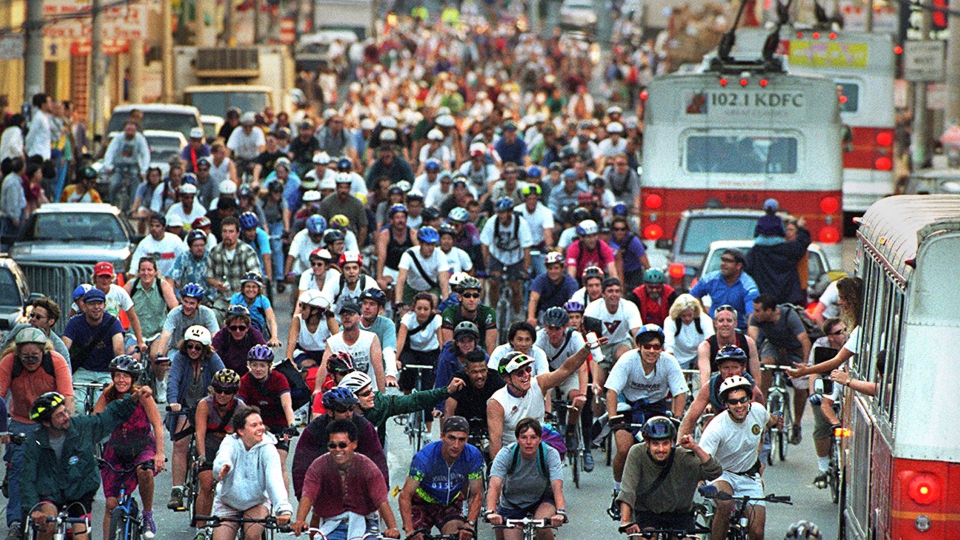 Crowd of bicyclers riding against traffic.