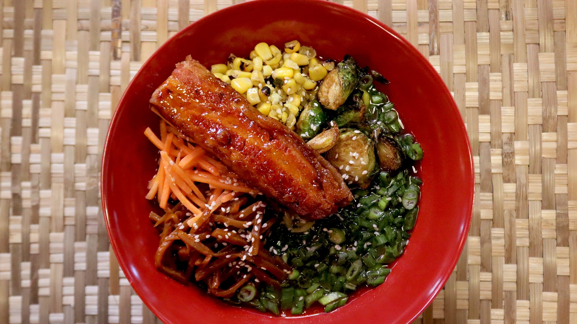 a bowl of ramen with pork belly on top