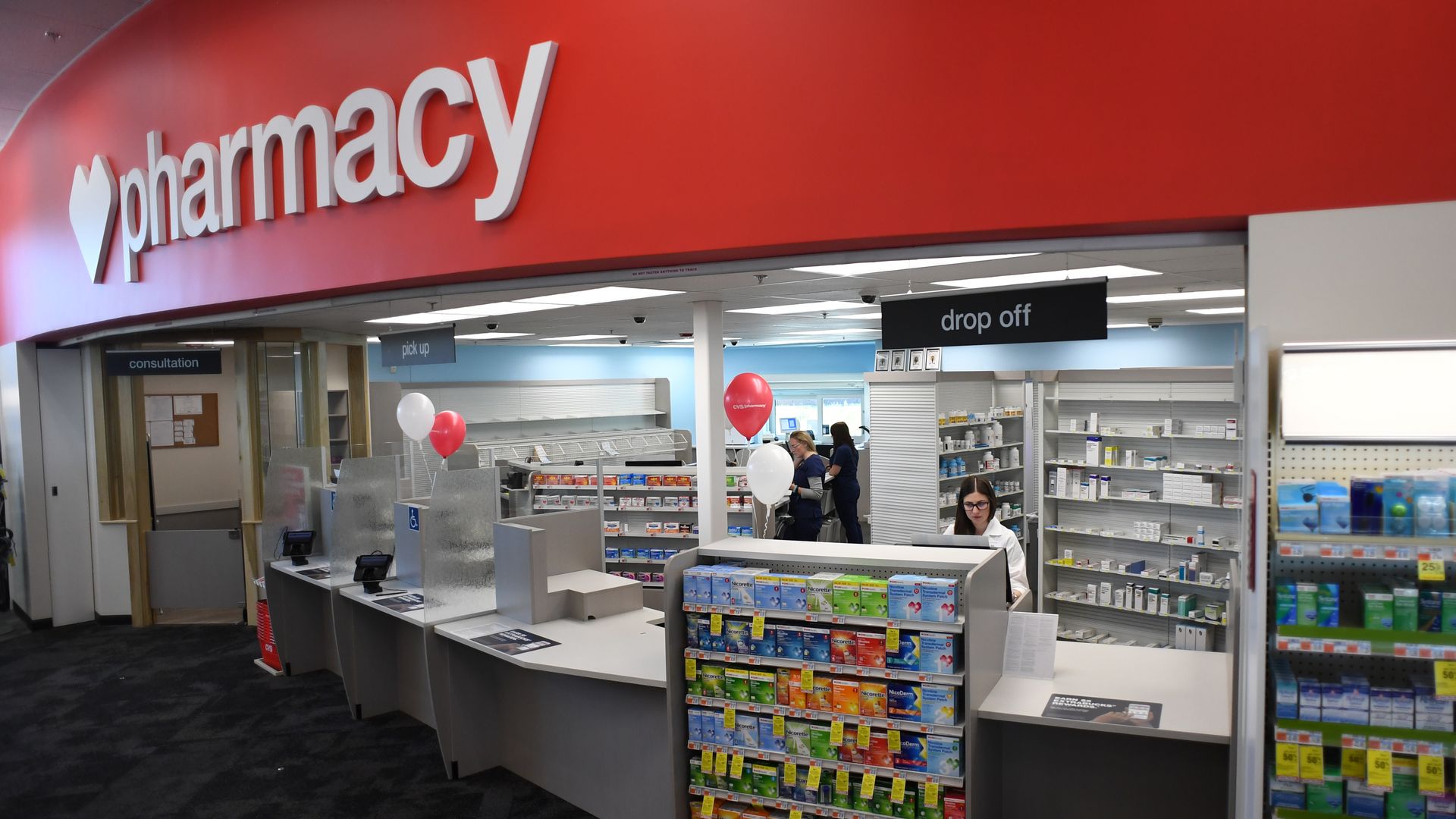 A CVS pharmacist stands behind the counter.