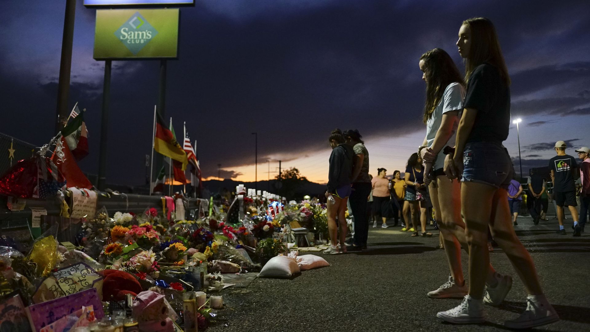 People look at flowers laid out to honor the victims of the El Paso shooting.