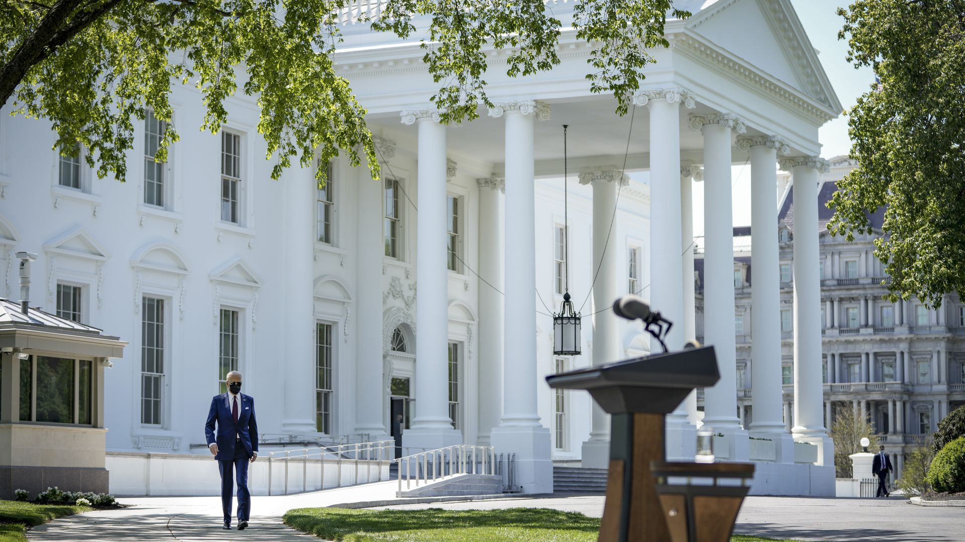 President Biden is seen approaching a podium installed on the North Lawn of the White House.