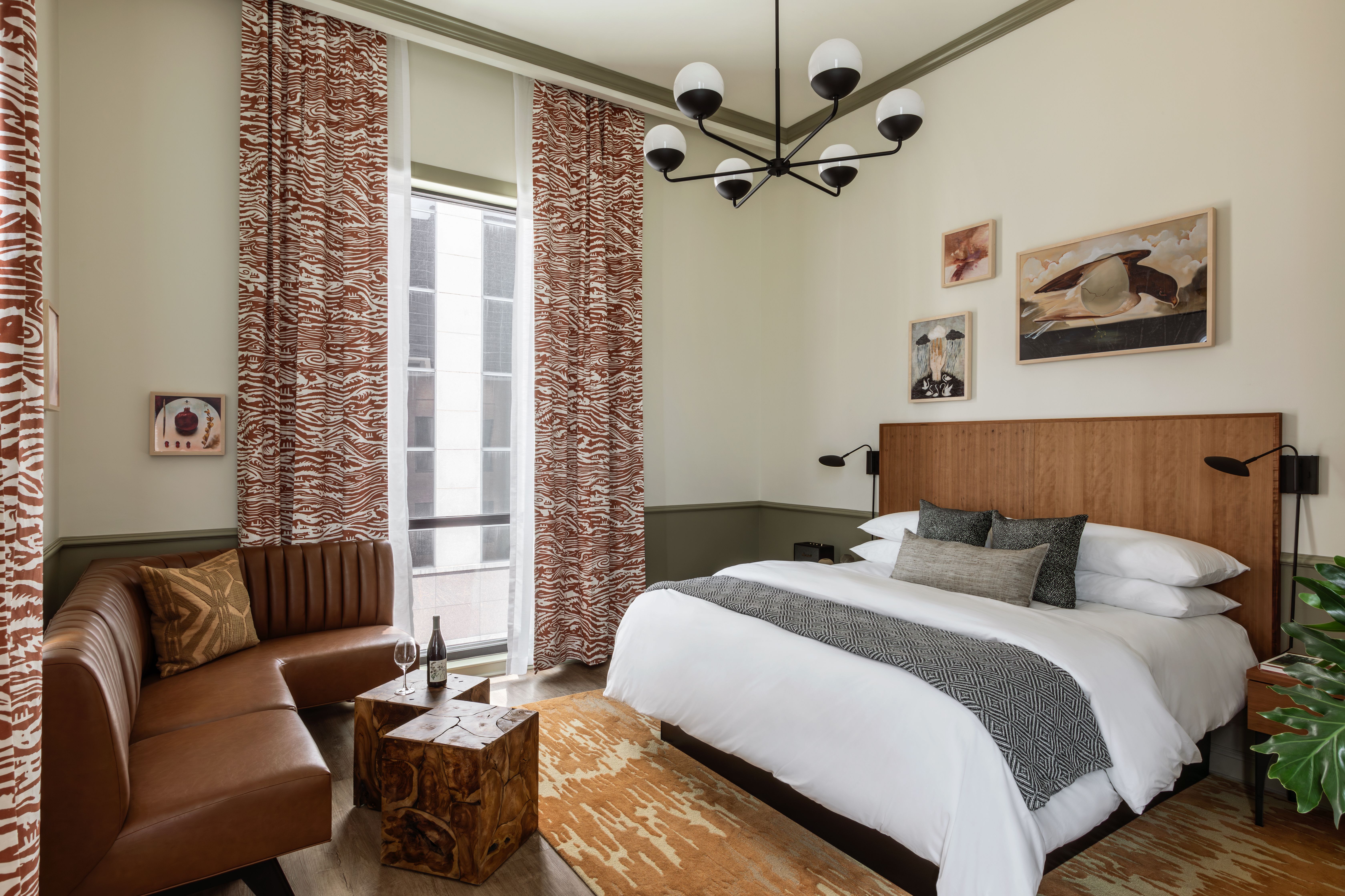 A modern-designed hotel room with a king bed at the center.