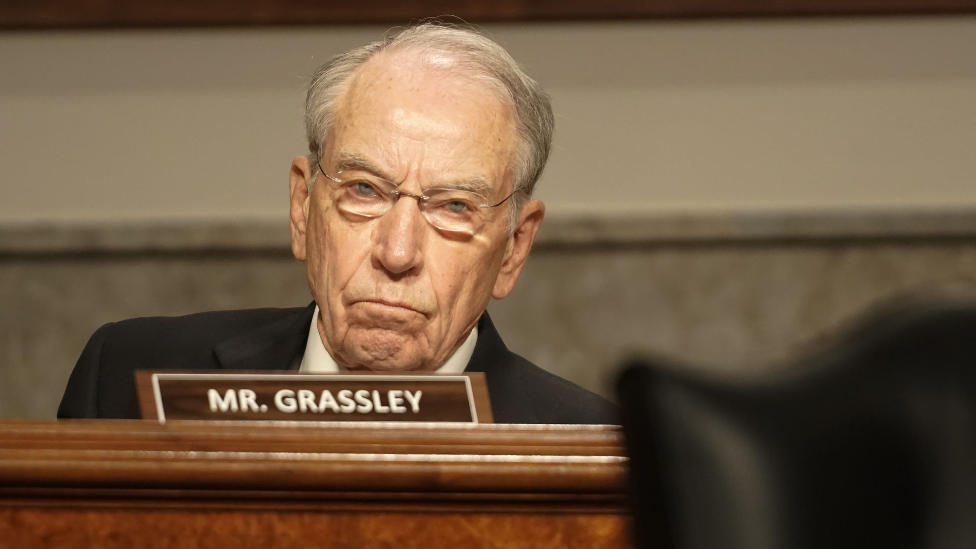 Chuck Grassley behind a nameplate 
