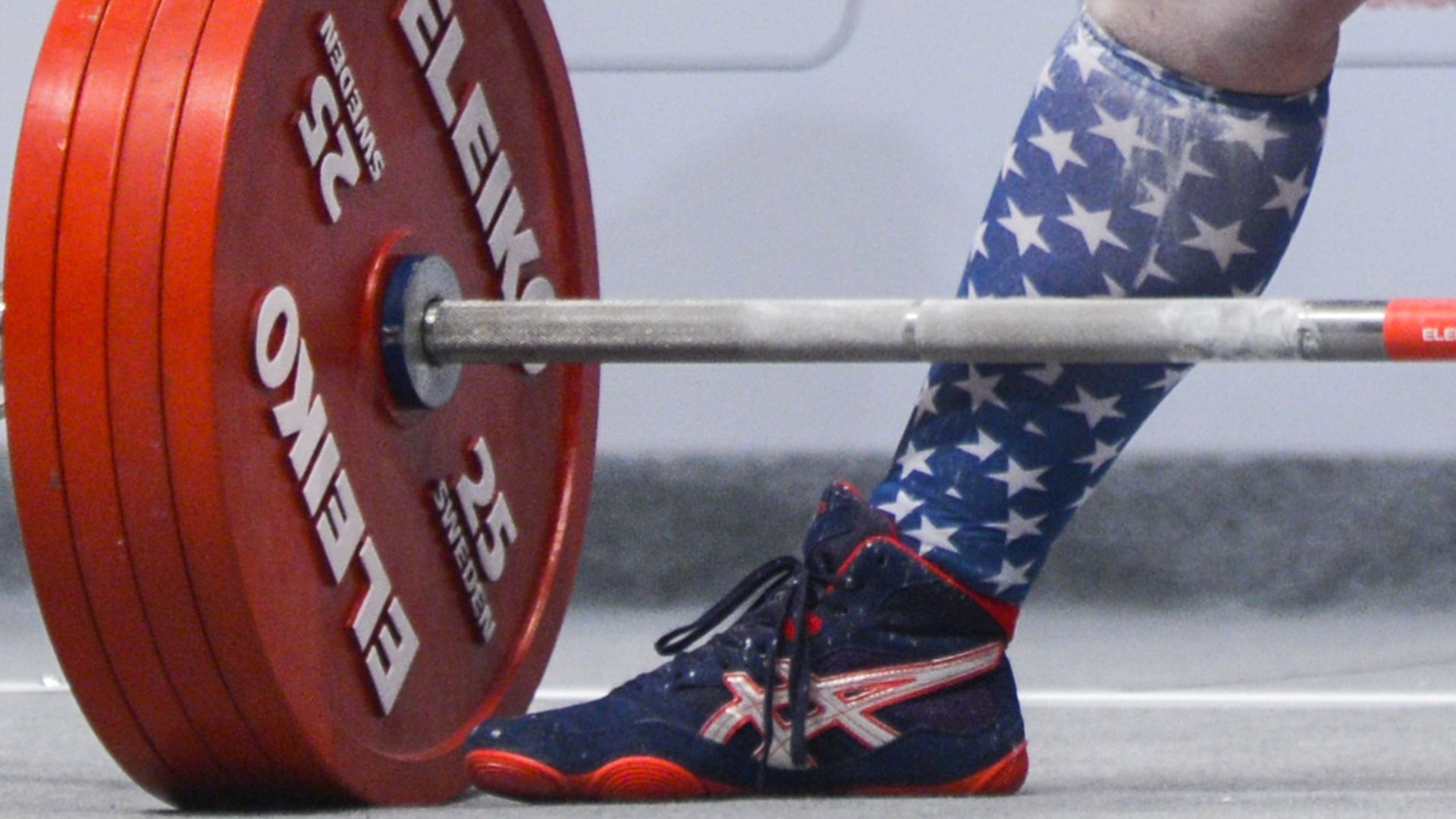 This image shows a close-up of a bell bar weighted down, and a sneaker.