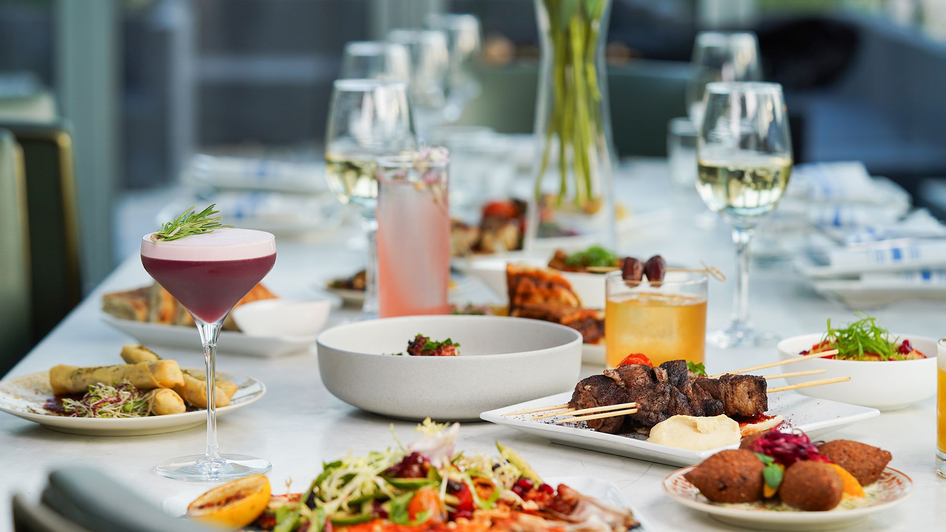 A table set with different Middle Eastern small plates and cocktails