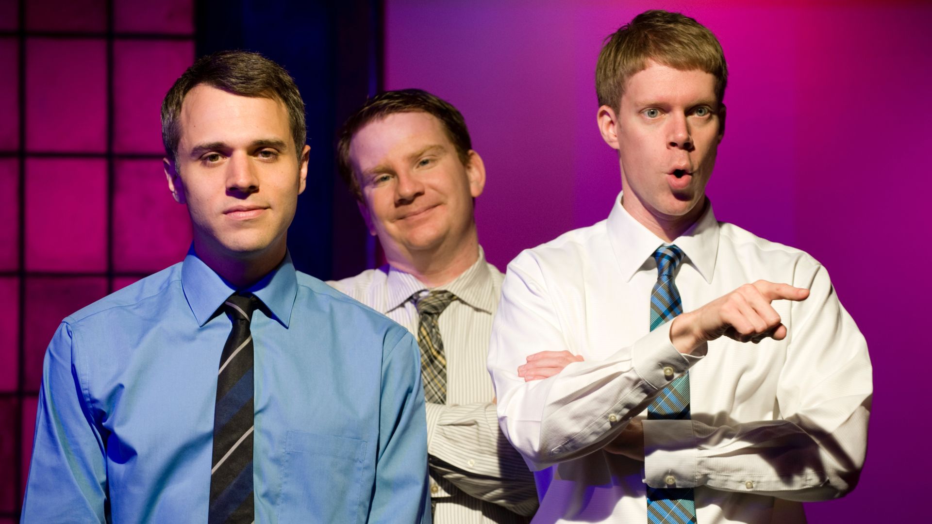Photo of three men on stage performing a sketch. 