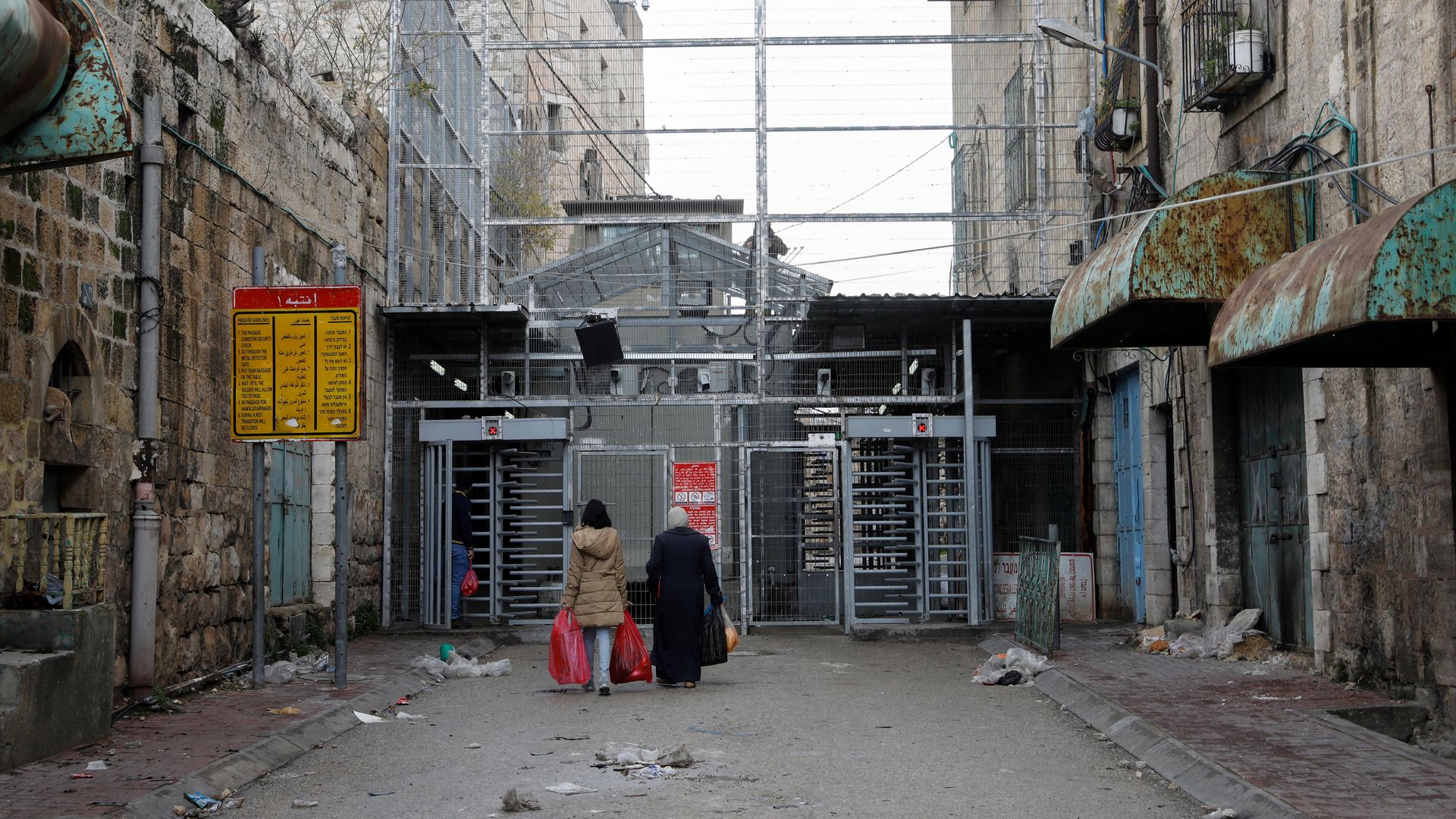 Two Palestinian women approach a checkpoint to cross into the Israeli-controlled Shuhada Street in the divided town of Hebron, in the Israeli occupied West Bank, on January 13, 2020.