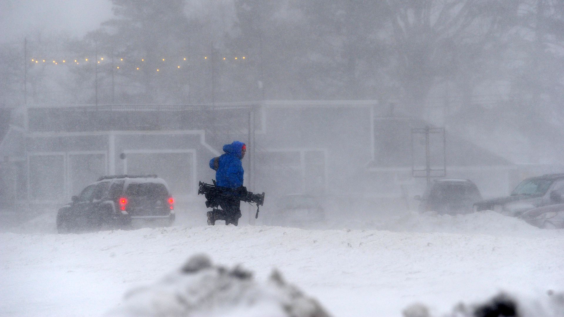  member of the media battles snow and ice as Lake Erie waters wash over the shoreline on December 23, 2022 in Hamburg, New York