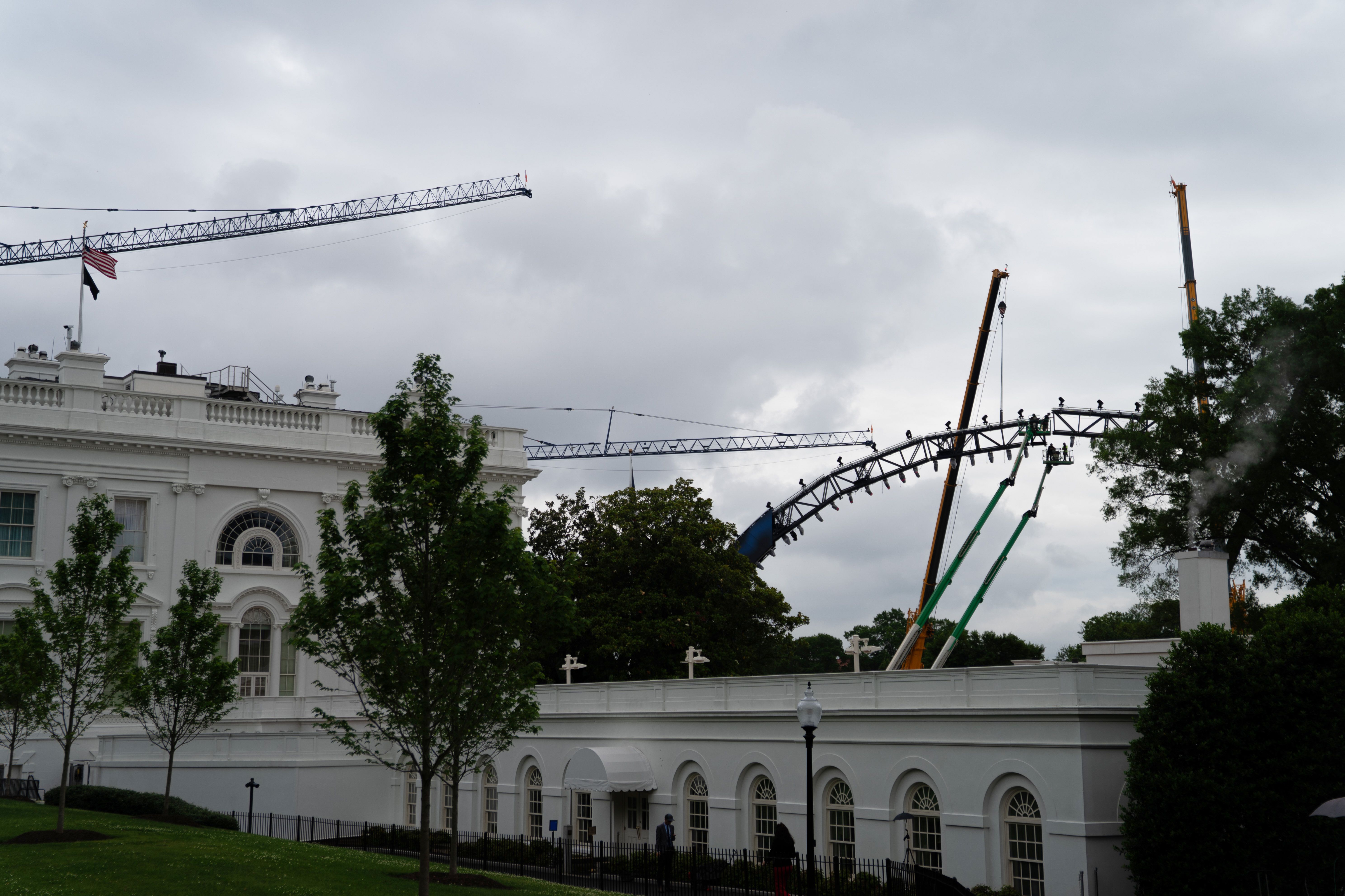 Crews work on the UFC fighting ring on the South Lawn yesterday.