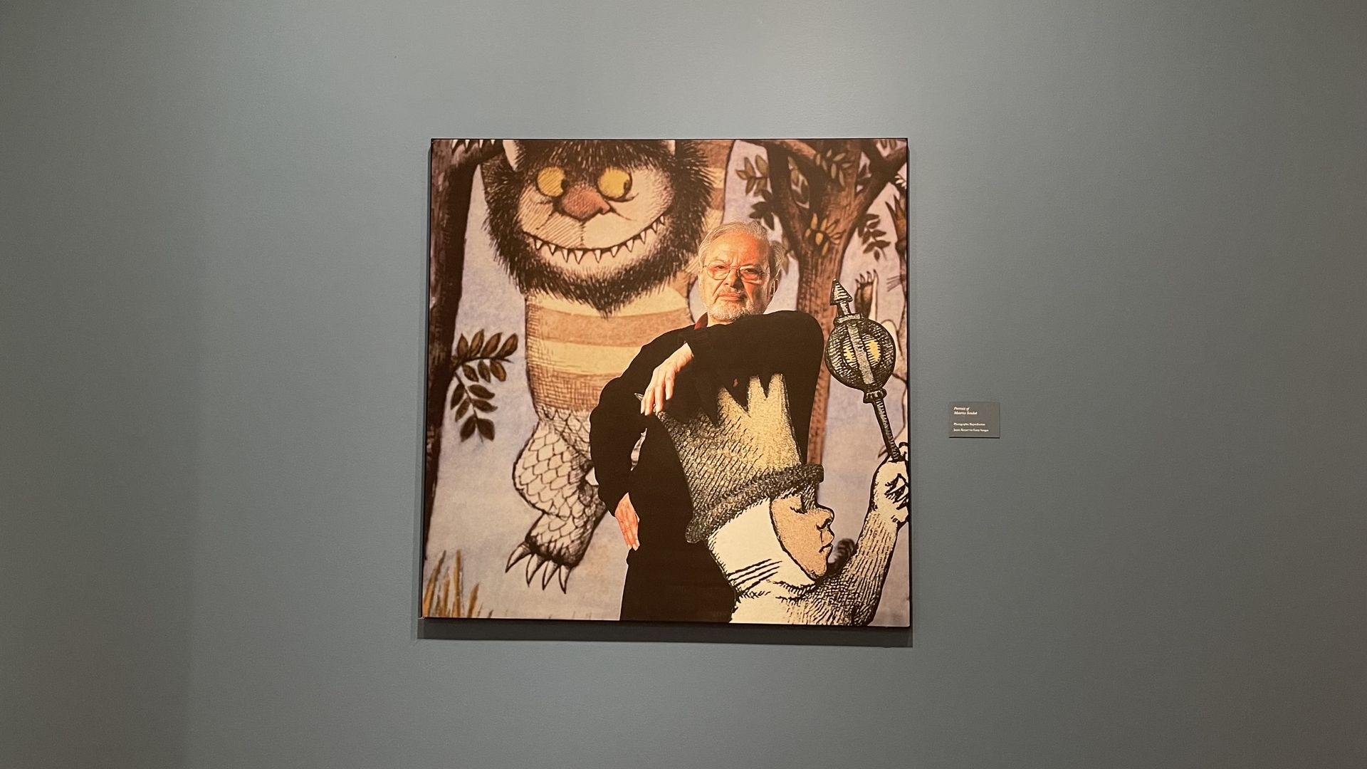 Photo of Maurice Sendak with his characters under a quote, "As a child I felt that books were holy objects, to be caressed, rapturously miffed, and devotedly provided for. I gave my life to them."