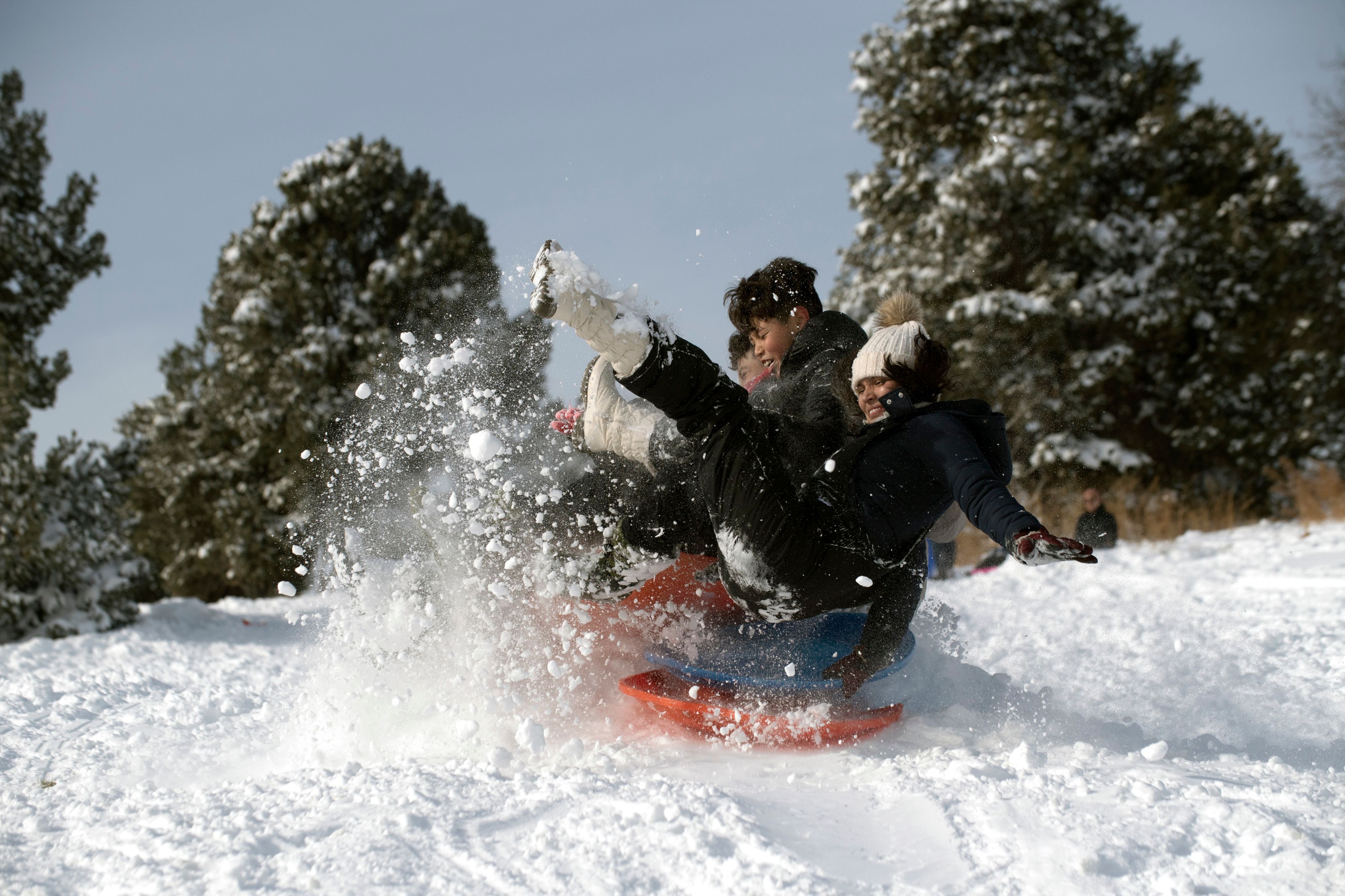 A family goes sledding at Ruby Hill Park in Denver, Colorado 