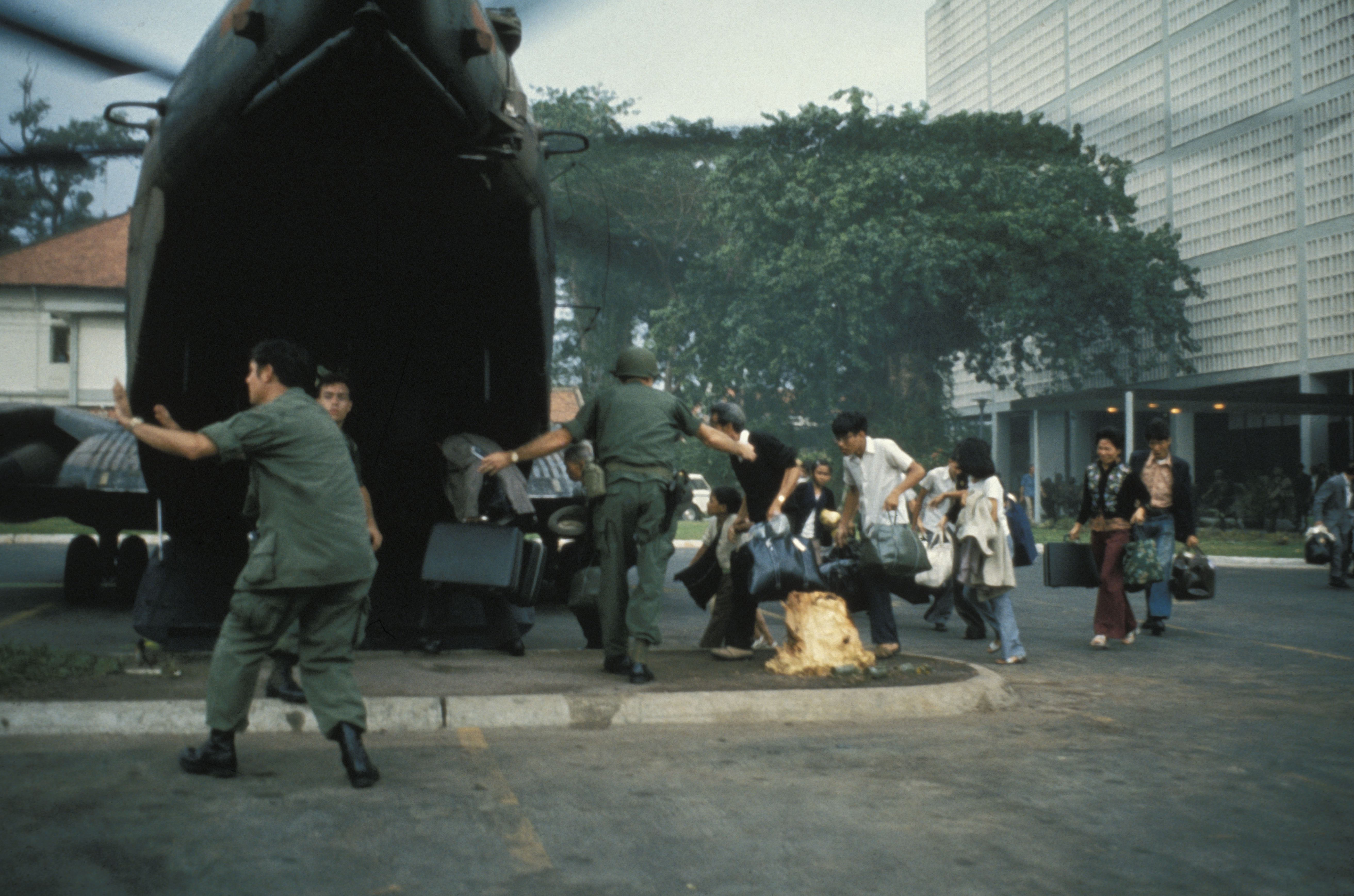 US civilians board helicopter inside the American Embassy compound in Saigon to escape advancing North Vietnamese about to capture Saigon. 