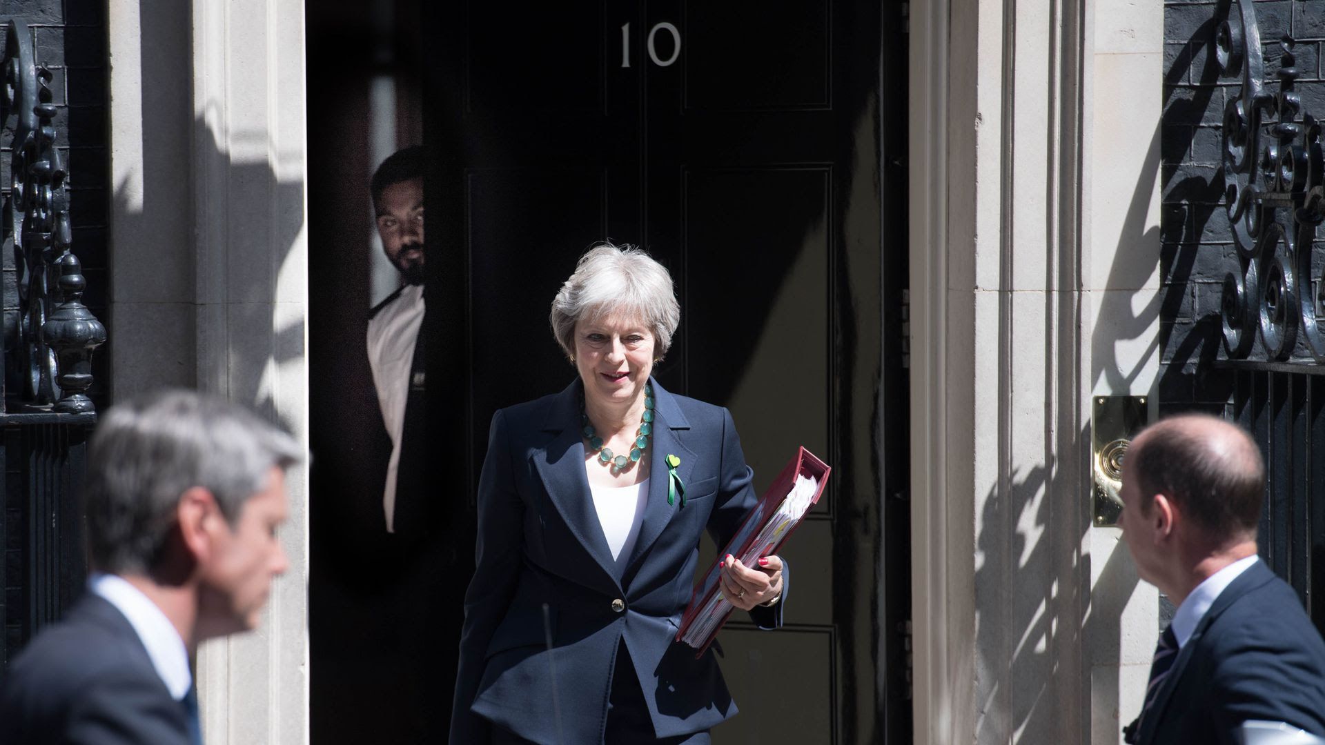 Theresa May walks down the stairs outside Number 10 in England