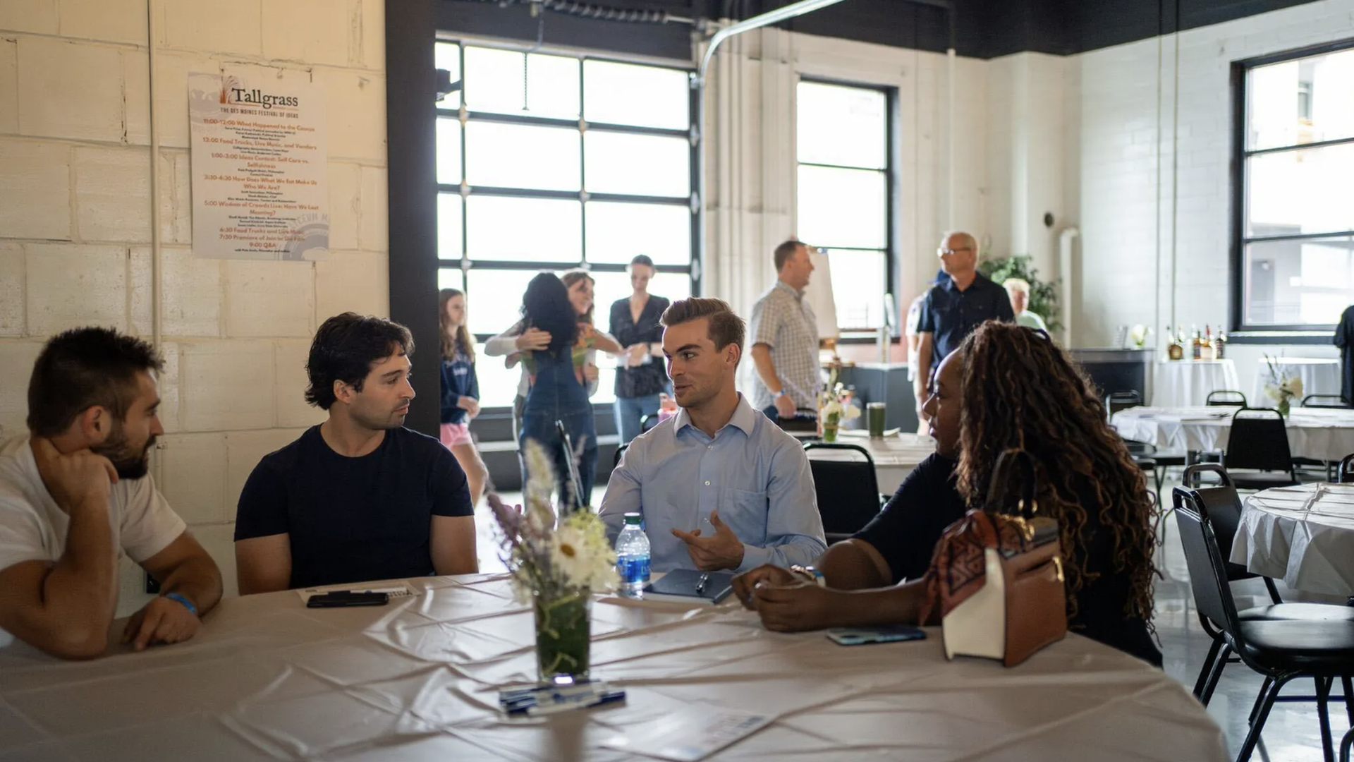 Four people seated around a table engaged in conversation.