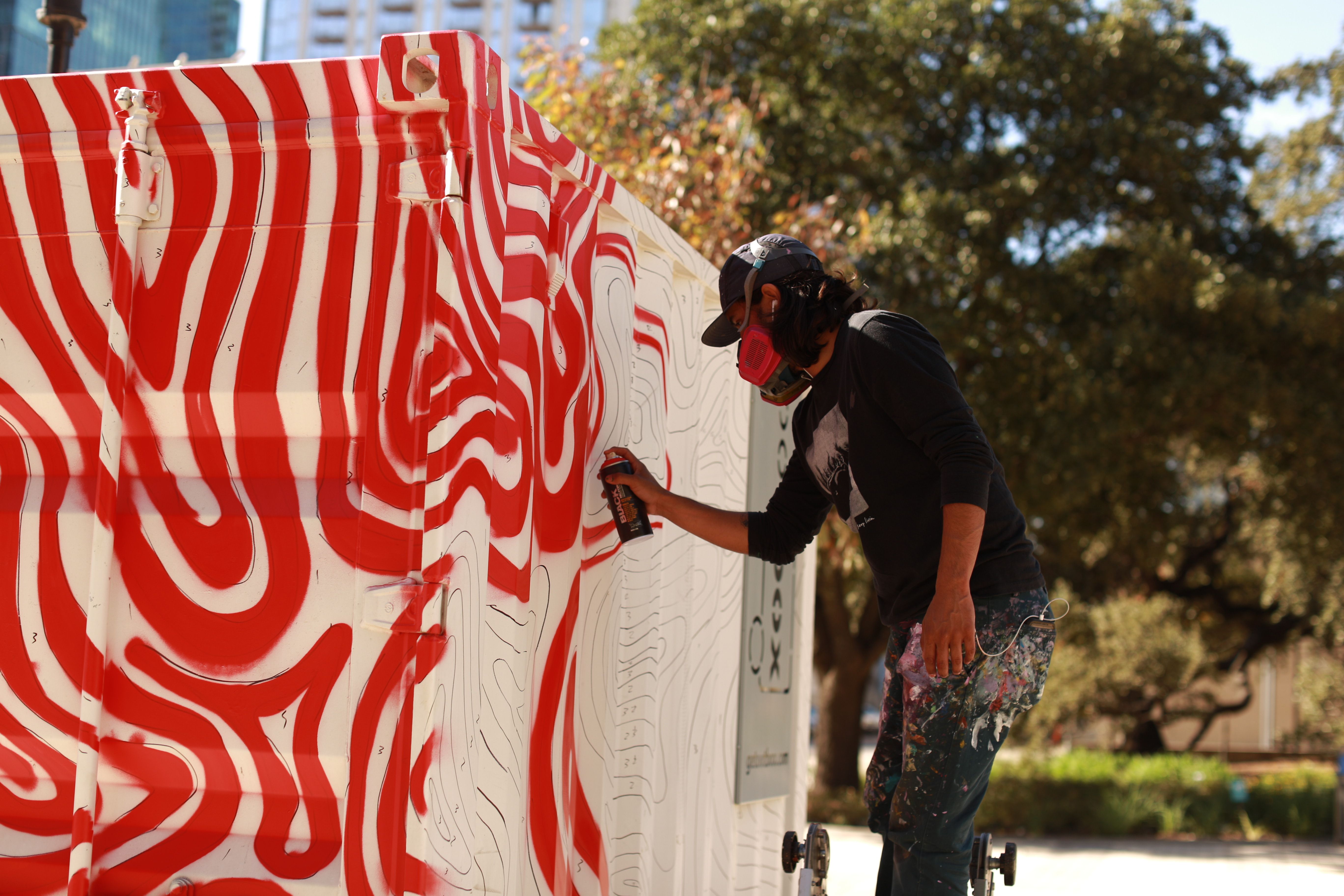 A photo of an artist spraying a container box.