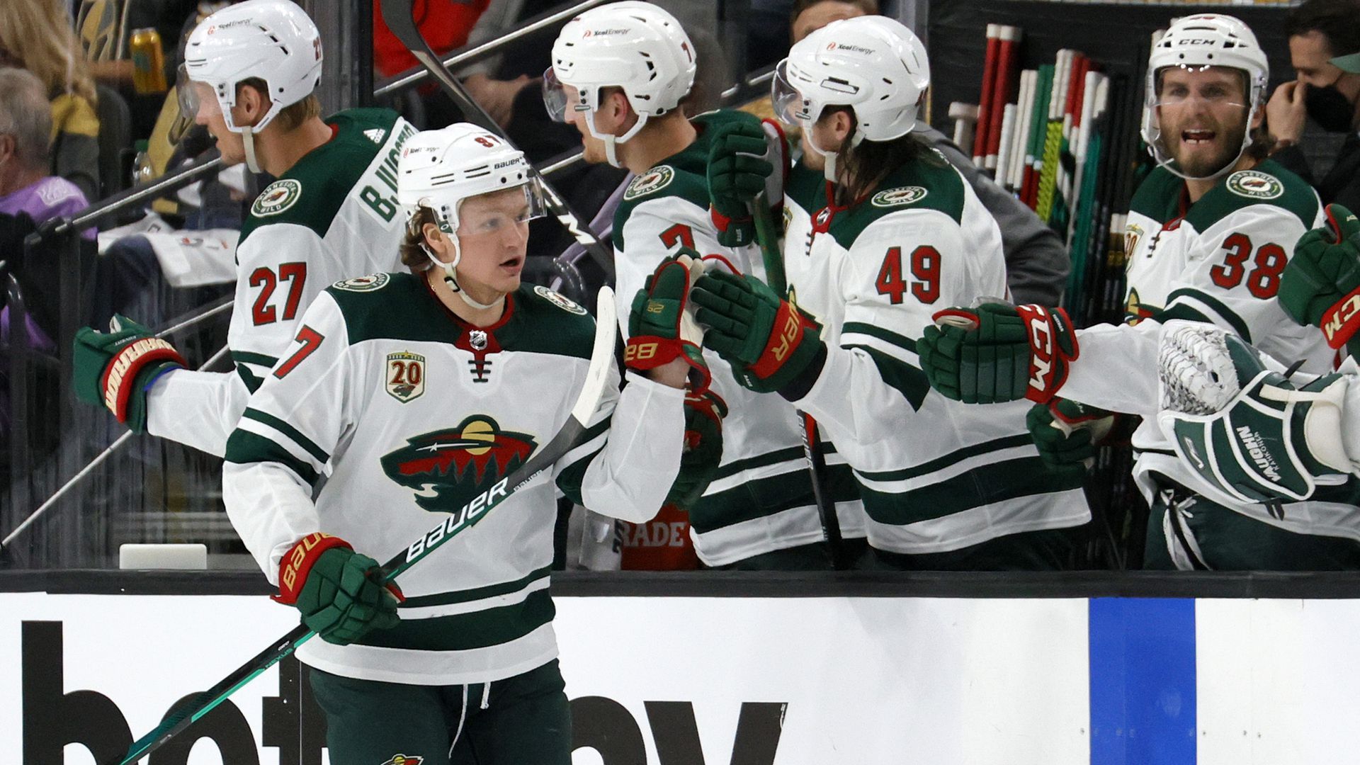 Minnesota Wild players high five on the ice.