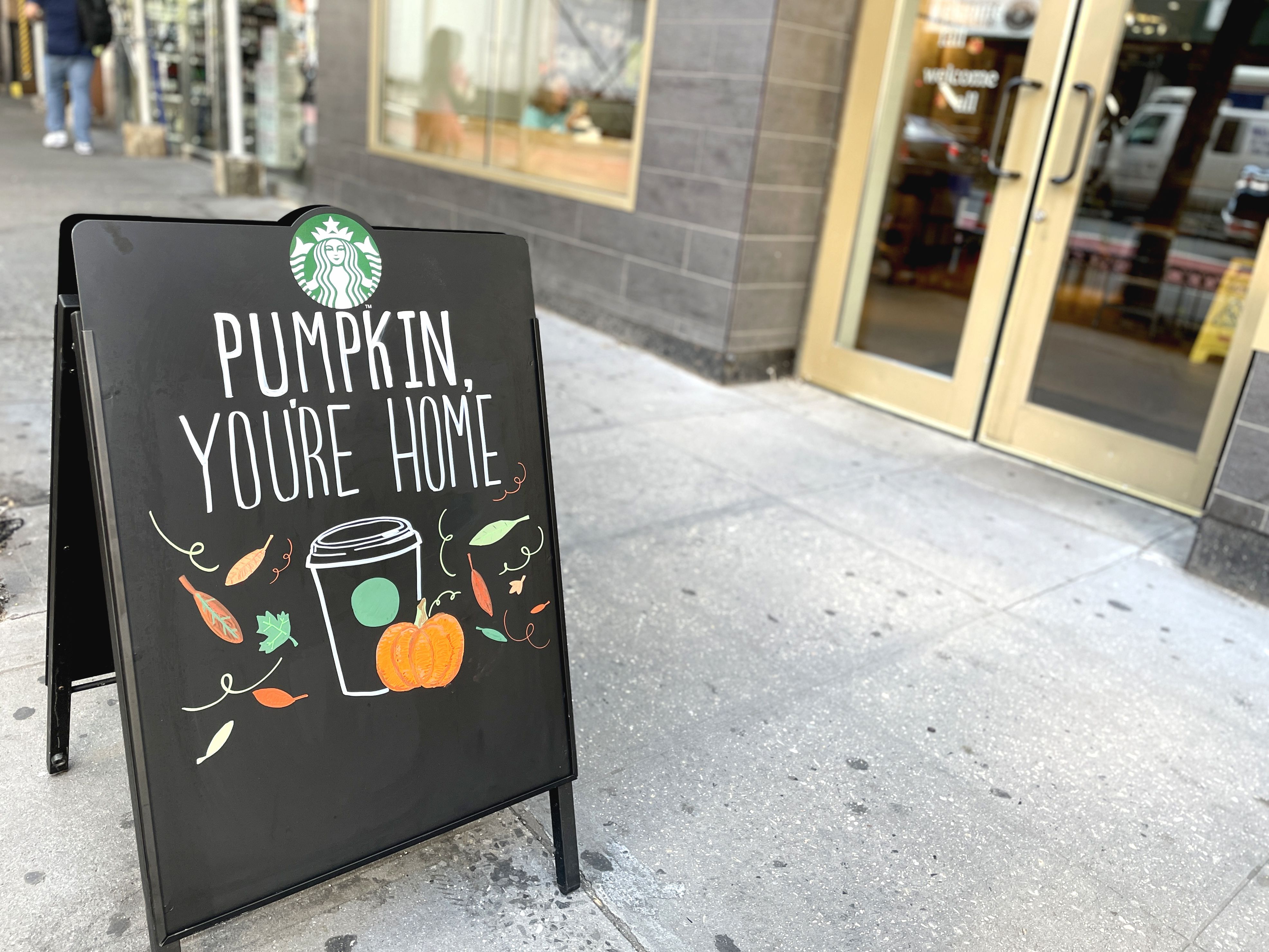 A sign outside a Starbucks that says "Pumpkin you're home"
