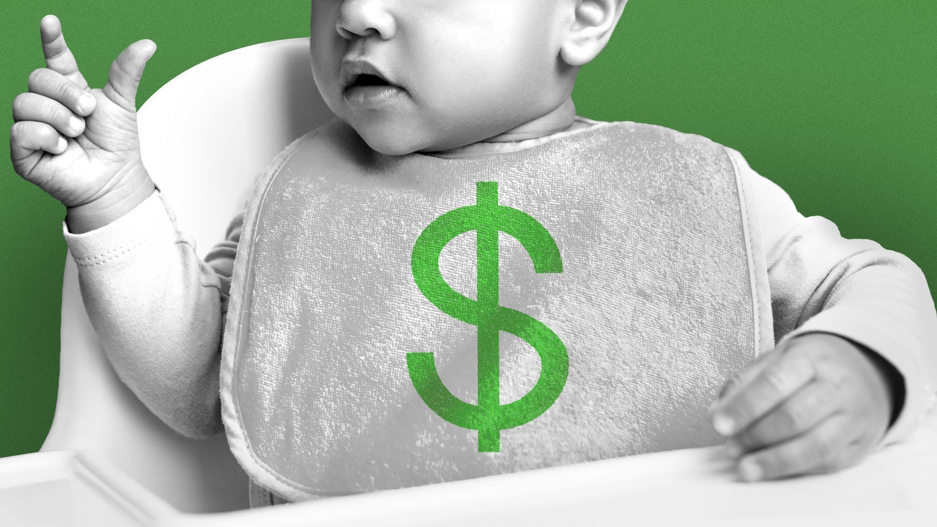 A baby in a highchair with a bib that has a green dollar sign on it. The baby is in black and white.