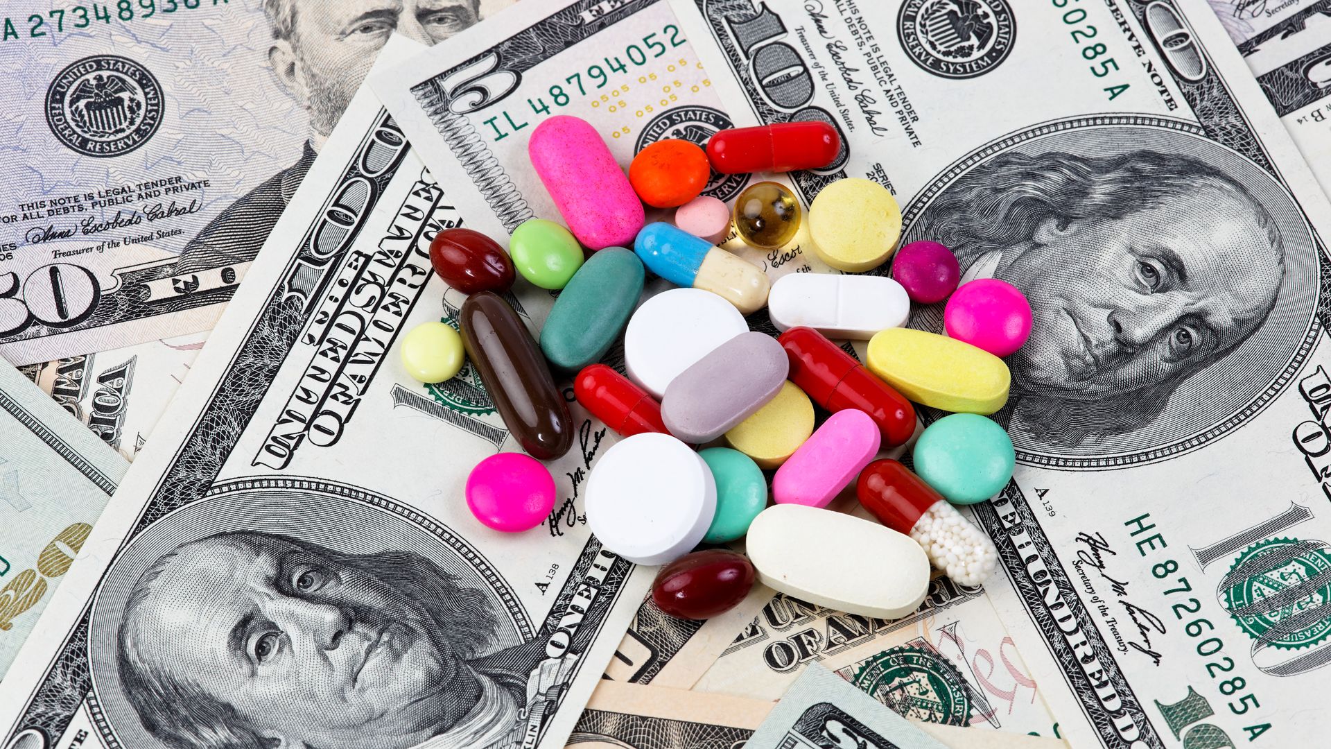 Prescription pills on top of dollar bills.