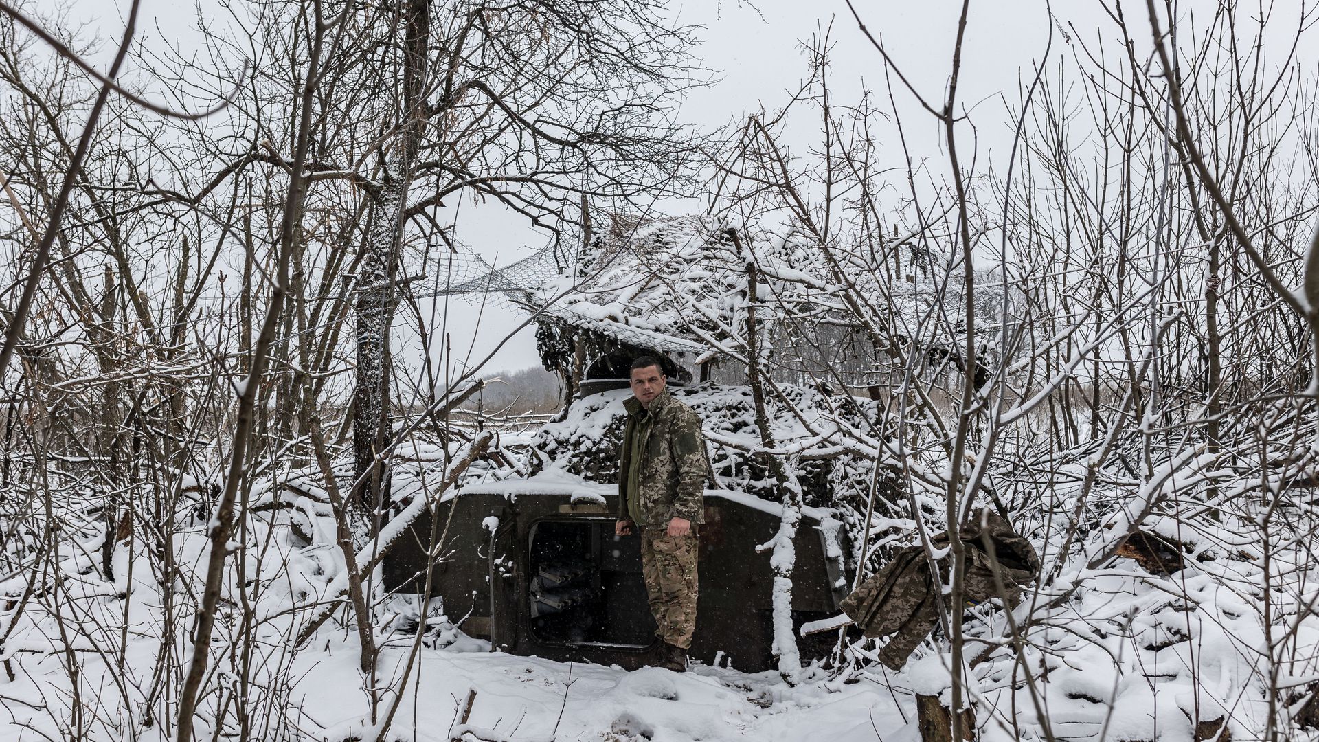Ukrainian soldier stands next to an artillery vehicle in his fighting position as Russia-Ukraine war continues