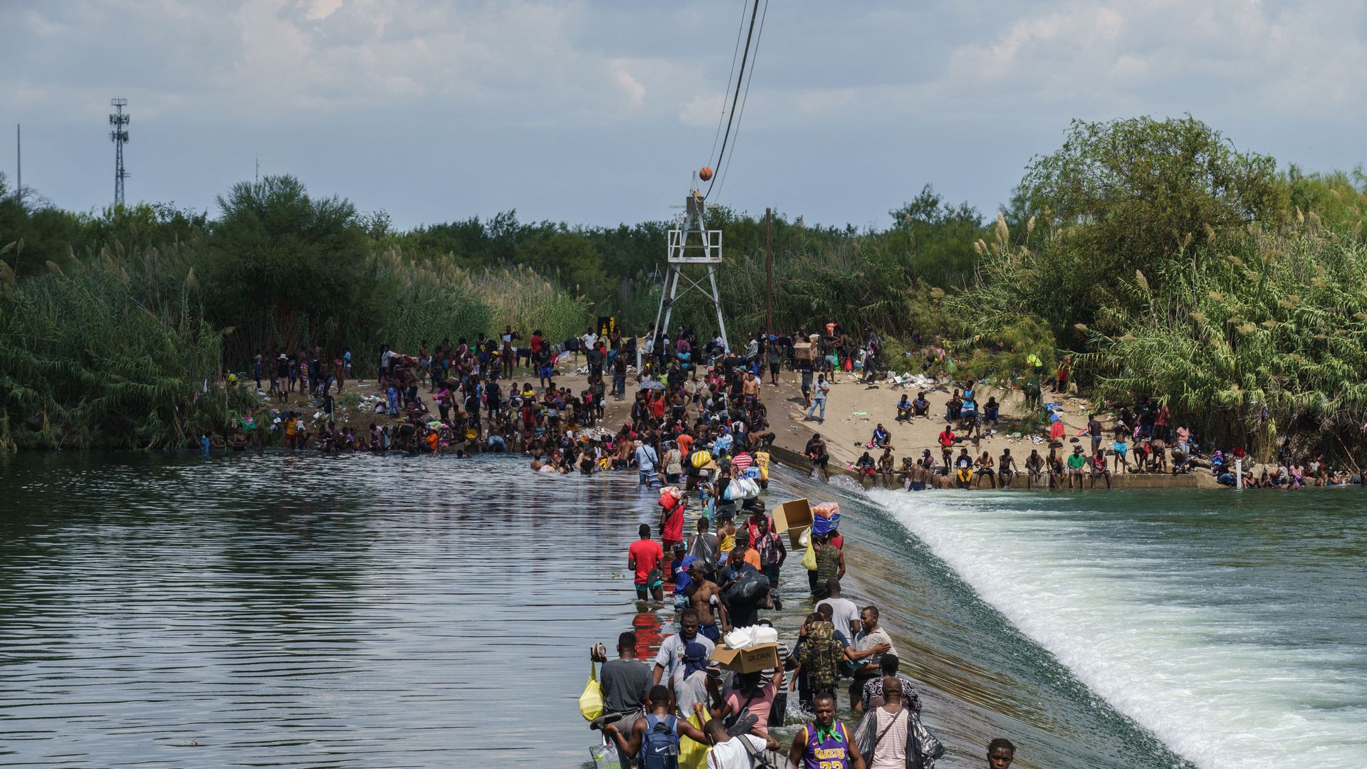 Migrants, many of them Haitian, cross the Rio Grande 