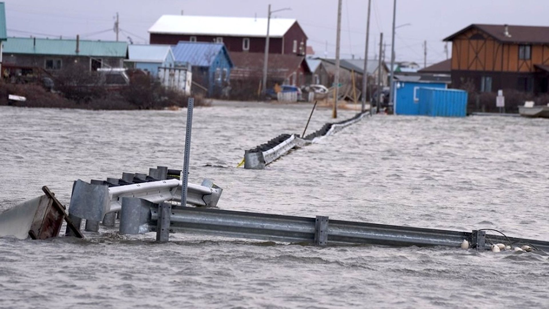 Flooding impacting a property in western Alaska, showing floodwaters inundating grounds of a home.