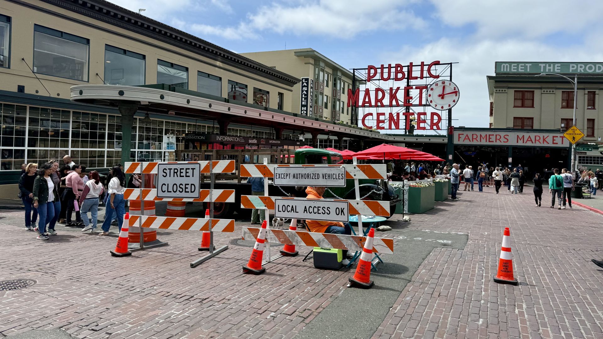 The First and Pike Street entrance to Pike Place Market has signs that say "Street Closed" and orange cones set up to block vehicles.