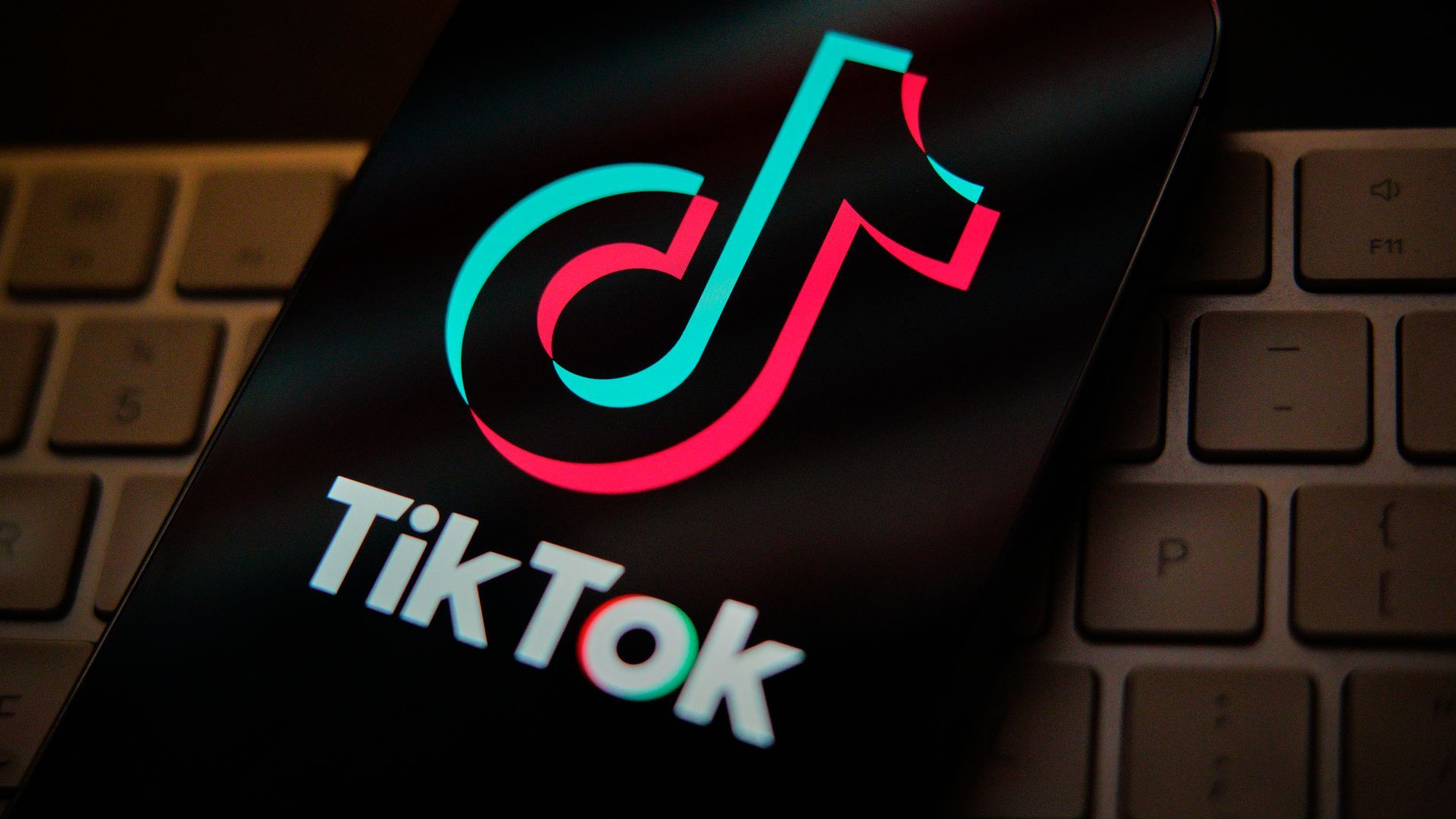 A TikTok logo in front of a brick background