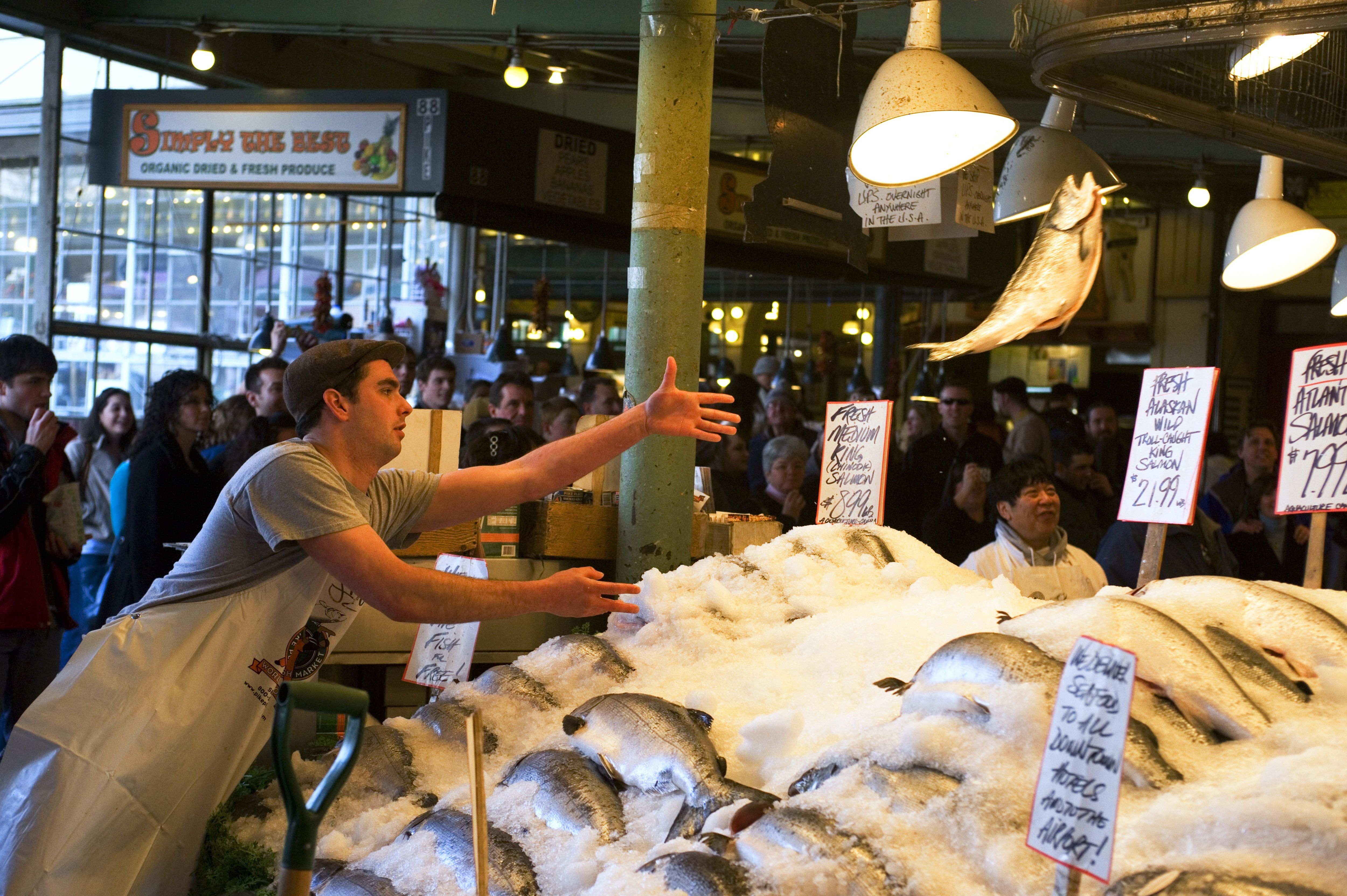 A person throwing a fish at Pike Place Market in Seattle. 