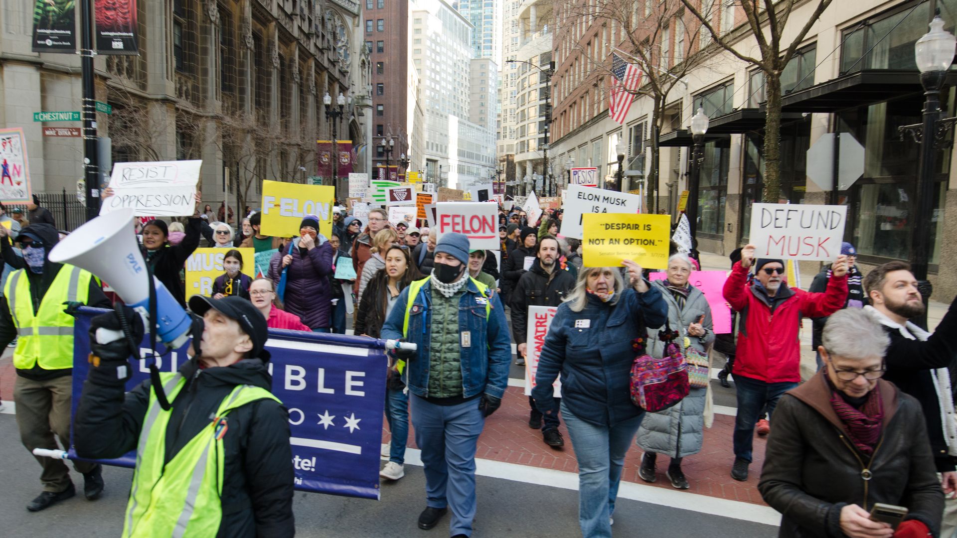 Photo of a large protest walking down a city street. 