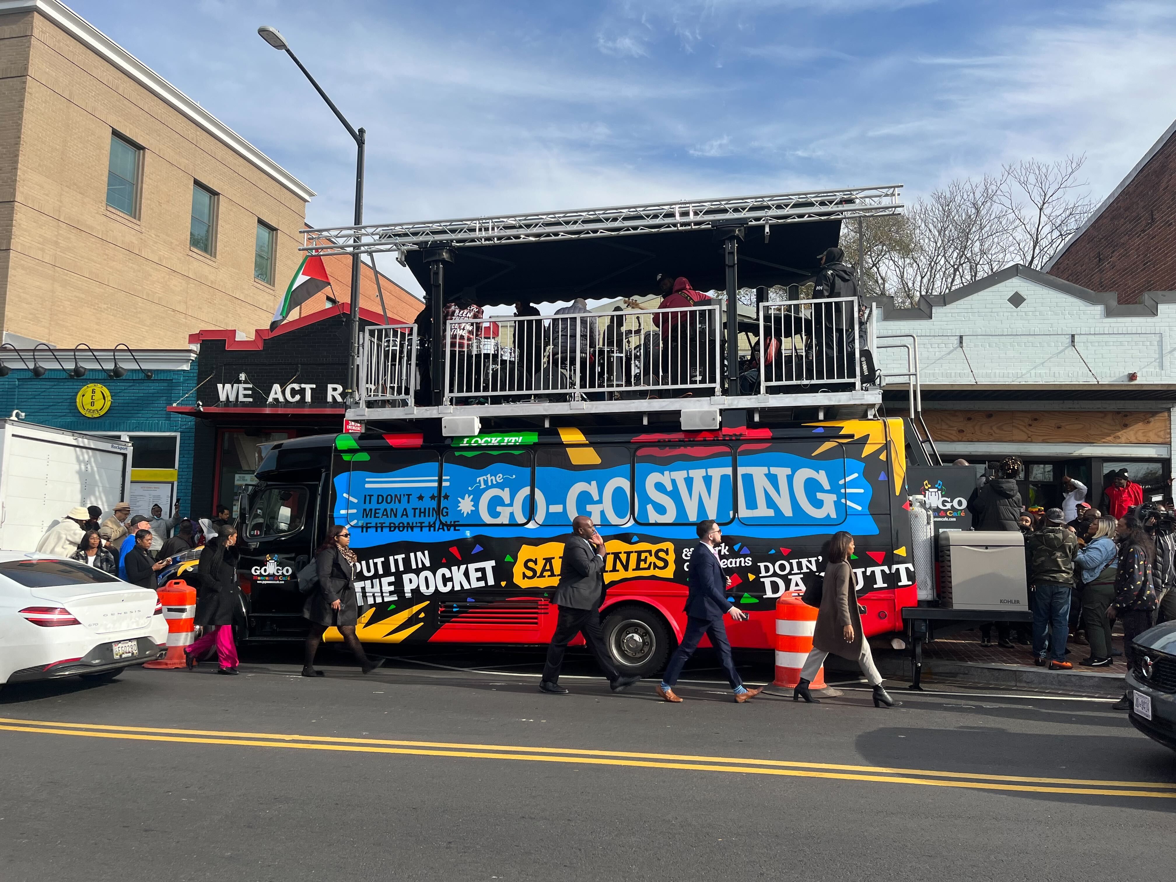 A giant bus that says "Go-Go Swing" on the side, parked on a street in D.C.