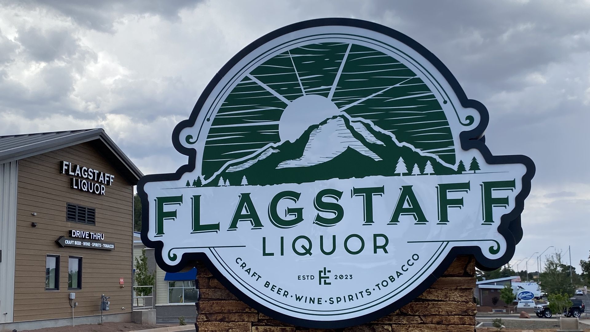A green and white sign that says Flagstaff Liquor.
