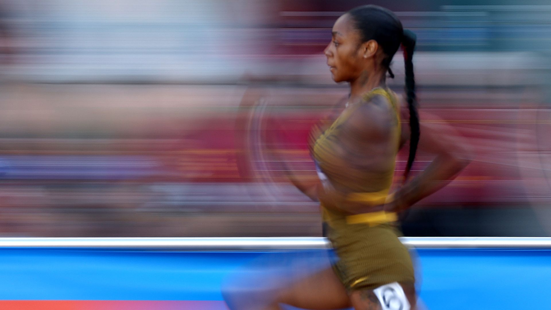A photo of Sha'Carri Richardson racing with the background blurred by her speed