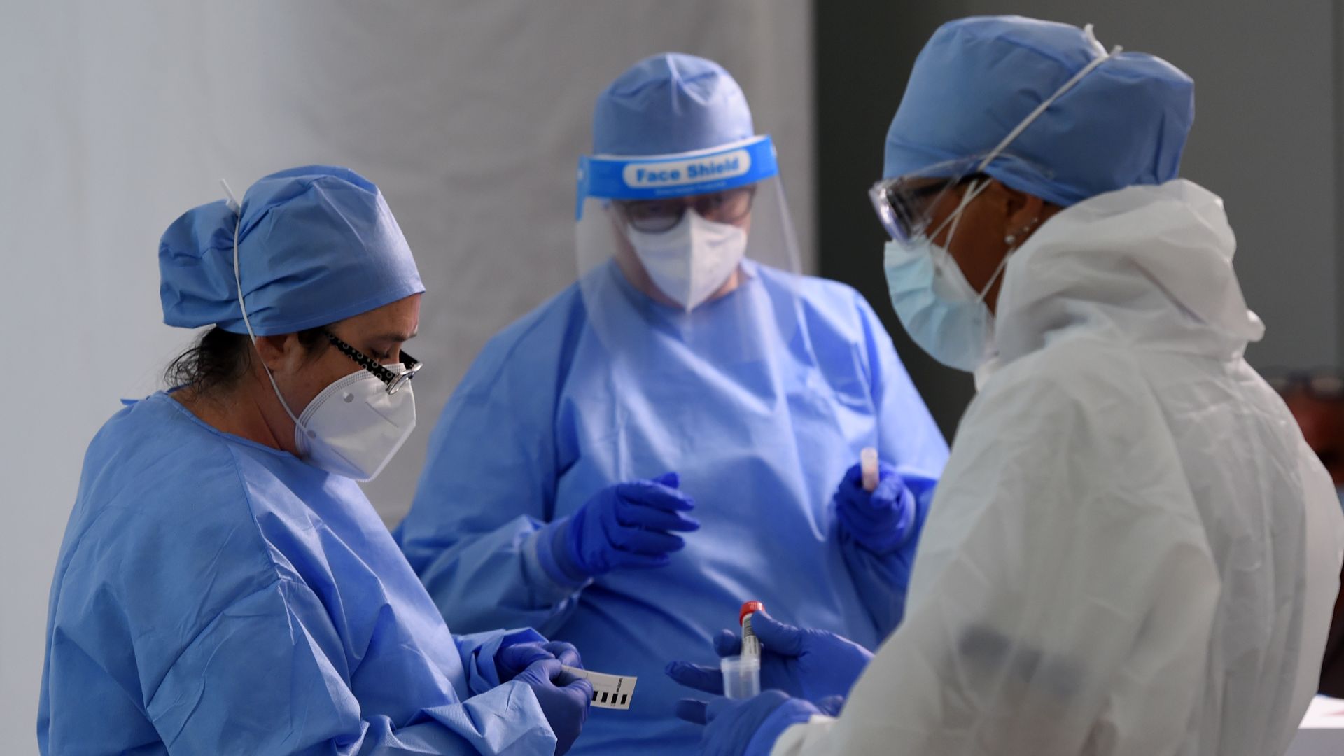 Some healthcare workers attend the travelers for swabs Covid-19 testing at Malpensa Airport