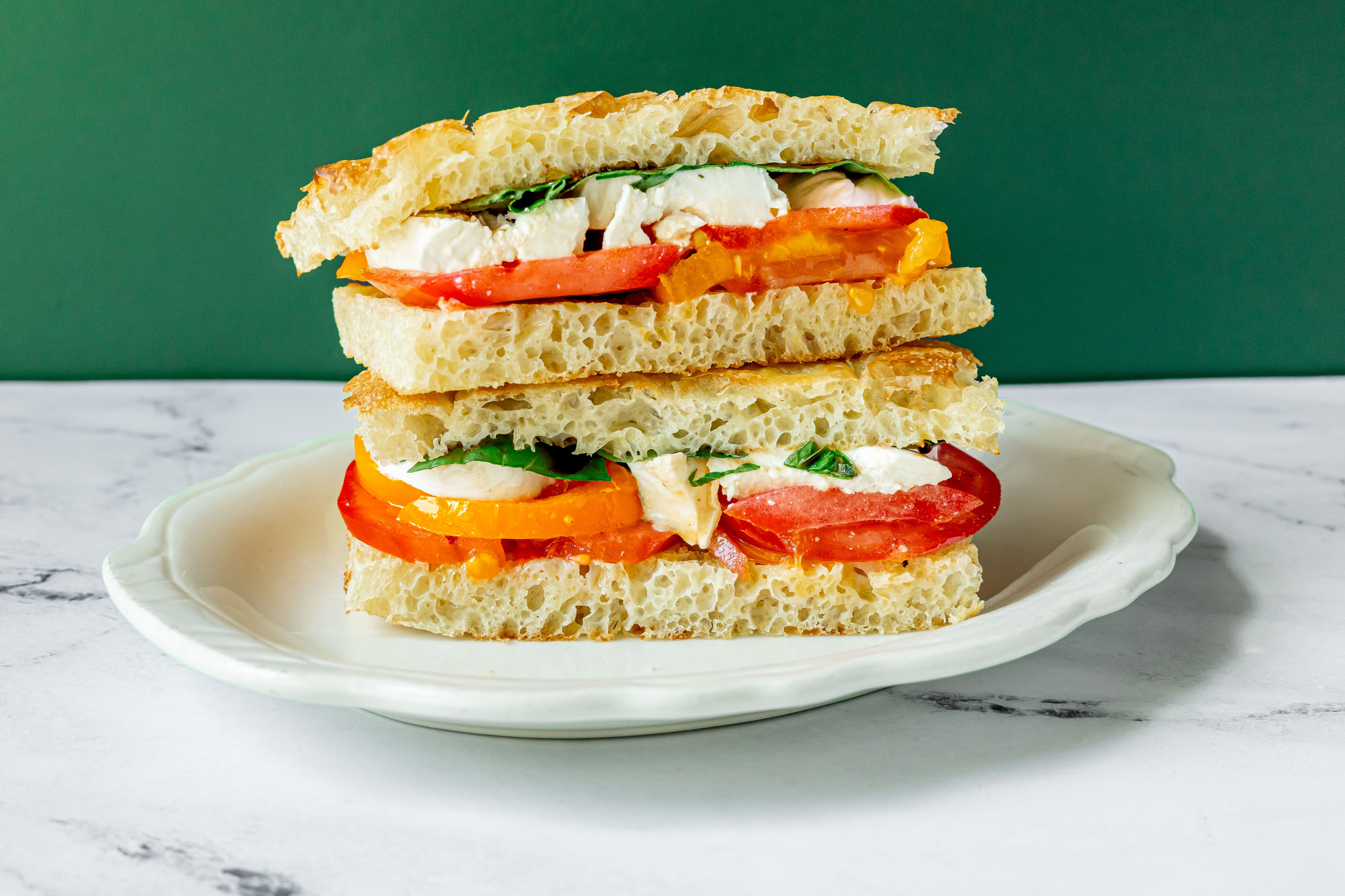 A summer tomato sandwich with basil and mozzarella